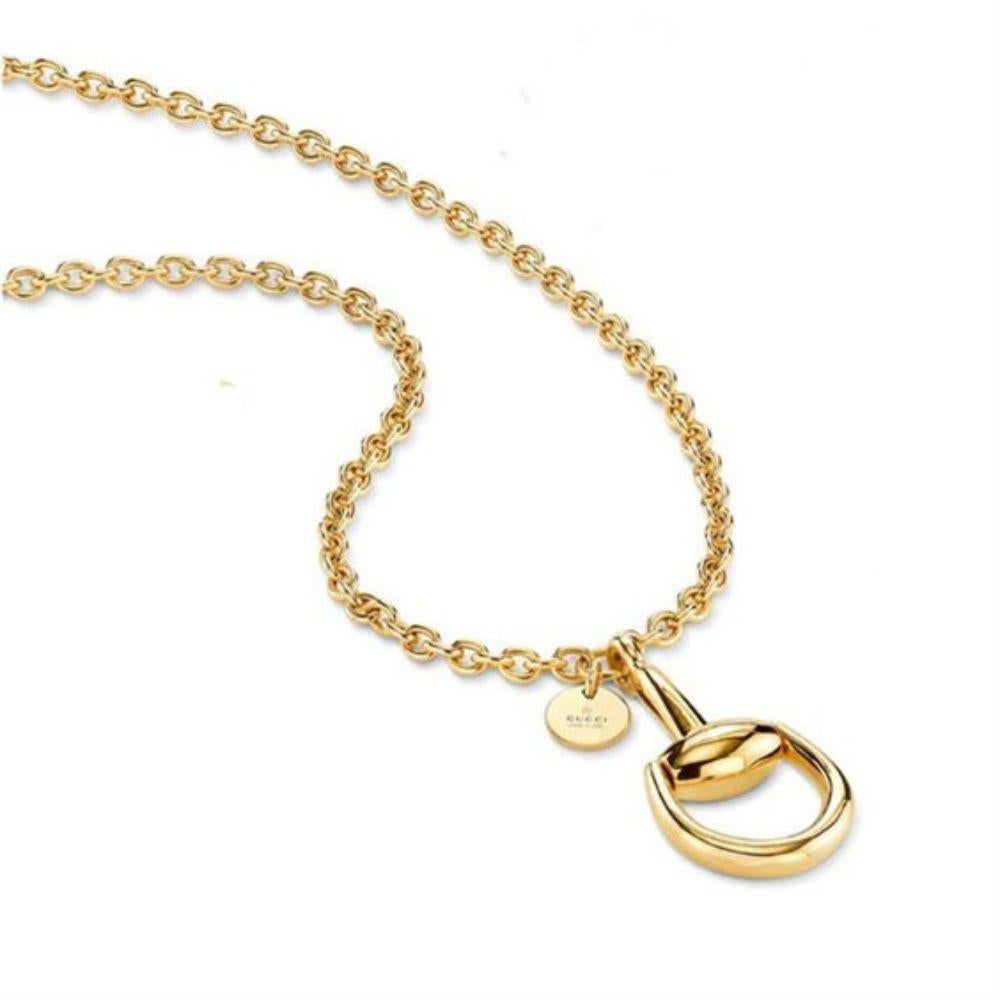 From Gucci's Iconic Horsebit Collection comes an exquisite 18K yellow gold necklace featuring a large equestrian-inspired polished pendant that represents the luxury of Gucci's brand. The Horsebit pendant is also accompanied by a round disc charm