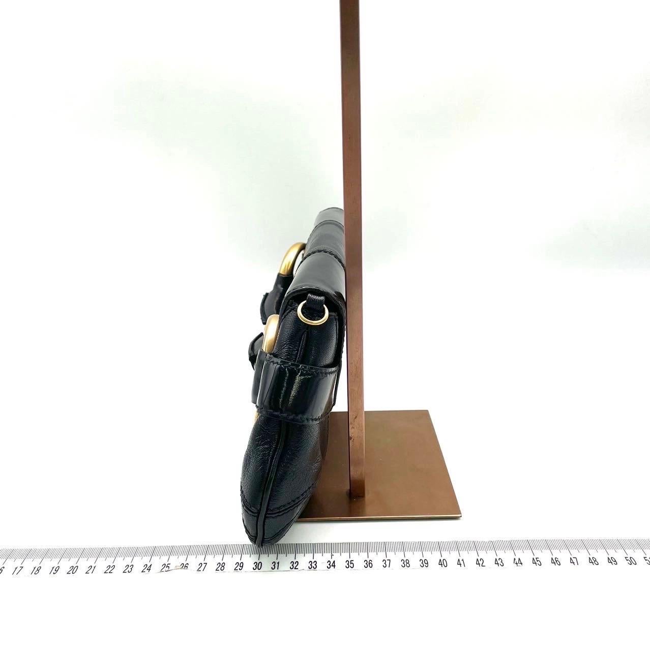 Faites-vous remarquer avec ce grand sac à bandoulière en cuir noir de Gucci. Fabriqué en cuir grainé noir résistant aux rayures, avec des accessoires et des clous dorés. Ce grand classique fera tourner les têtes !


Ce modèle est remis au goût du