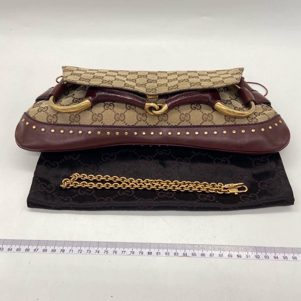 Fai una dichiarazione con questa grande borsa a tracolla di Gucci. Realizzata con l'iconico Monogram di Gucci in tessuto beige, pelle bordeaux e finiture dorate. Questo classico farà girare la testa a tutti!

Questo modello viene riproposto nella