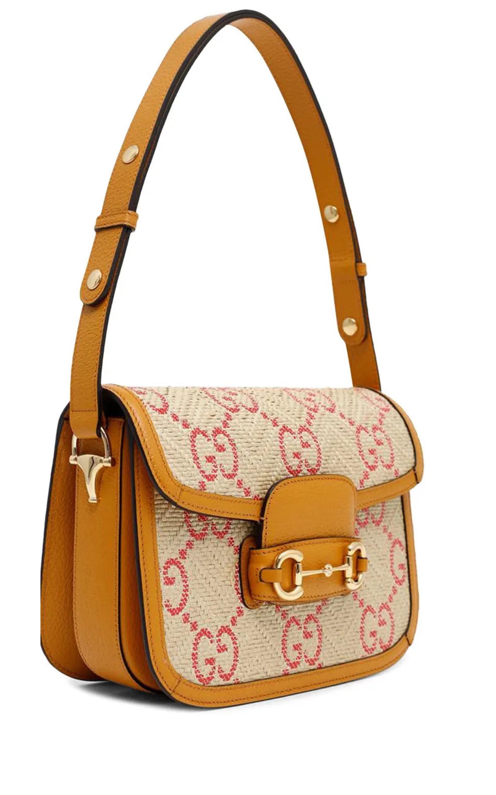 This Horsebit 1955 Pink Raffia Shoulder Bag is presented in raffia-effect fabric with a GG motif and leather trim.
Beige and red GG raffia effect fabric
Dark yellow leather trim
Gold-toned hardware
Cotton linen lining
Horsebit detail at the