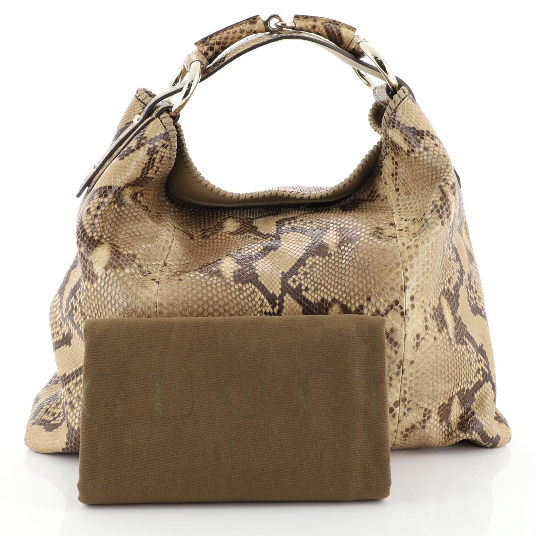 This Gucci Horsebit Hobo Python Large, crafted from genuine brown python skin, features single loop handle with horsebit and ring accents and gold-tone hardware. Its zip closure opens to a neutral fabric interior with zip pocket. These are