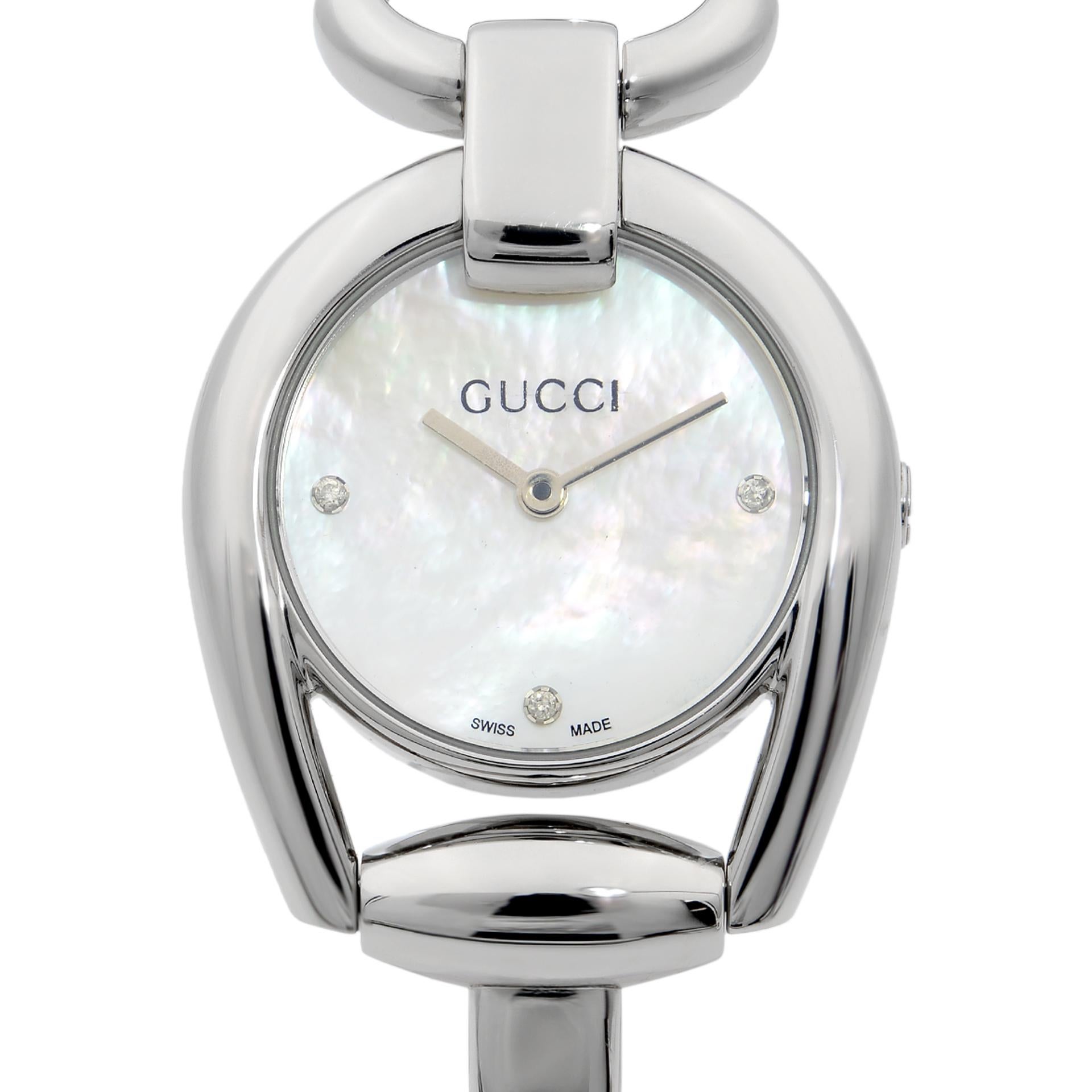 This pre-owned Gucci Horsebit  YA139506 is a beautiful Ladie's timepiece that is powered by quartz (battery) movement which is cased in a stainless steel case. It has a round shape face, no features dial and has hand unspecified style markers. It is