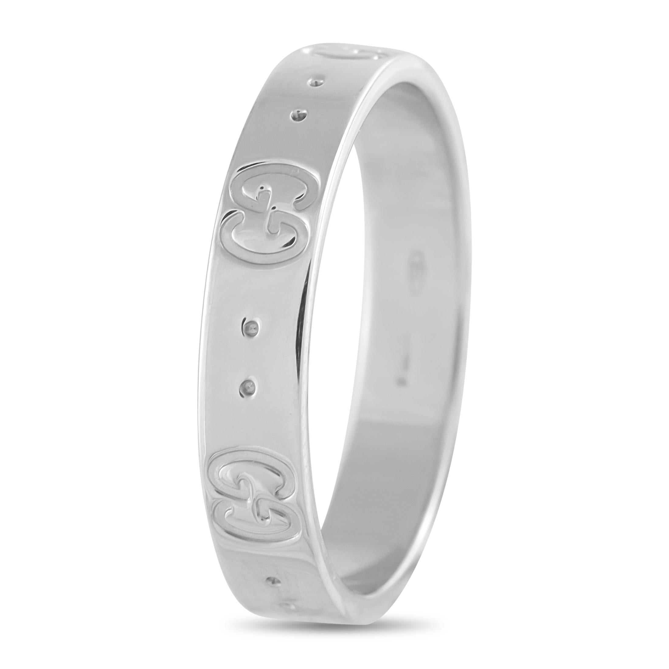 This Gucci Icon ring in 18K white gold features a 5mm band with a smooth, polished finish. Its surface is engraved with alternating GG motifs and double-dot detailing, arranged in precise alignment around the circumference. The minimal relief and