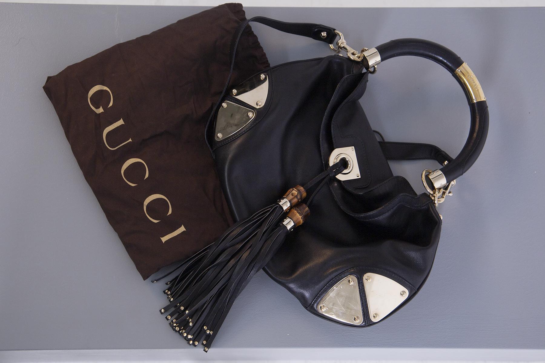 Elegant and fashionable Gucci Babouska Indy black shoulder bag. Made of leather and golden metal details still with its never used fur. This Gucci issue has a top with two tassels with bamboo details and a spacious fabric interior. It also features