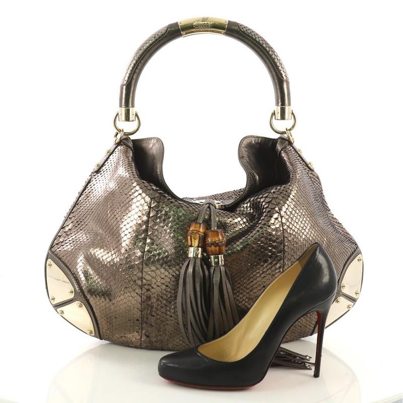 This Gucci Indy Hobo Python Large, crafted from genuine green gold metallic python skin, features bamboo and fringe tassels, looped handle, and gold-tone hardware. It opens to a green gold leather interior with side zip pocket. **Note: Shoe