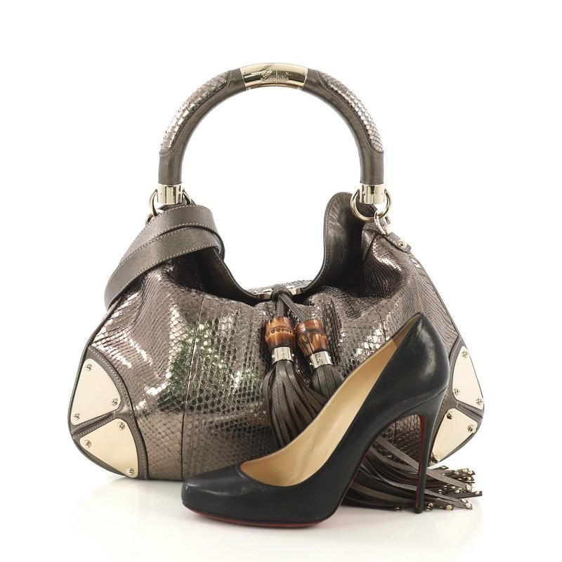 This Gucci Indy Hobo Python Medium, crafted from genuine gold python skin, features bamboo and fringe tassels, looped handle, and gold-tone hardware. It opens to a gold leather interior with side zip pocket. **Note: Shoe photographed is used as a