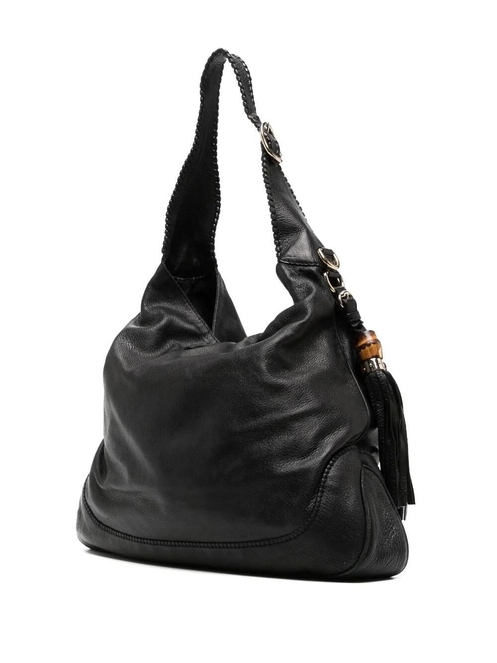 The Gucci Indy Jackie Hobo bag is a classic staple from the 2010 Resort Collection. Crafted from supple black grained leather and bamboo tassels, the design features silver hardware with the iconic 'Jackie' front closure, a braided shoulder strap