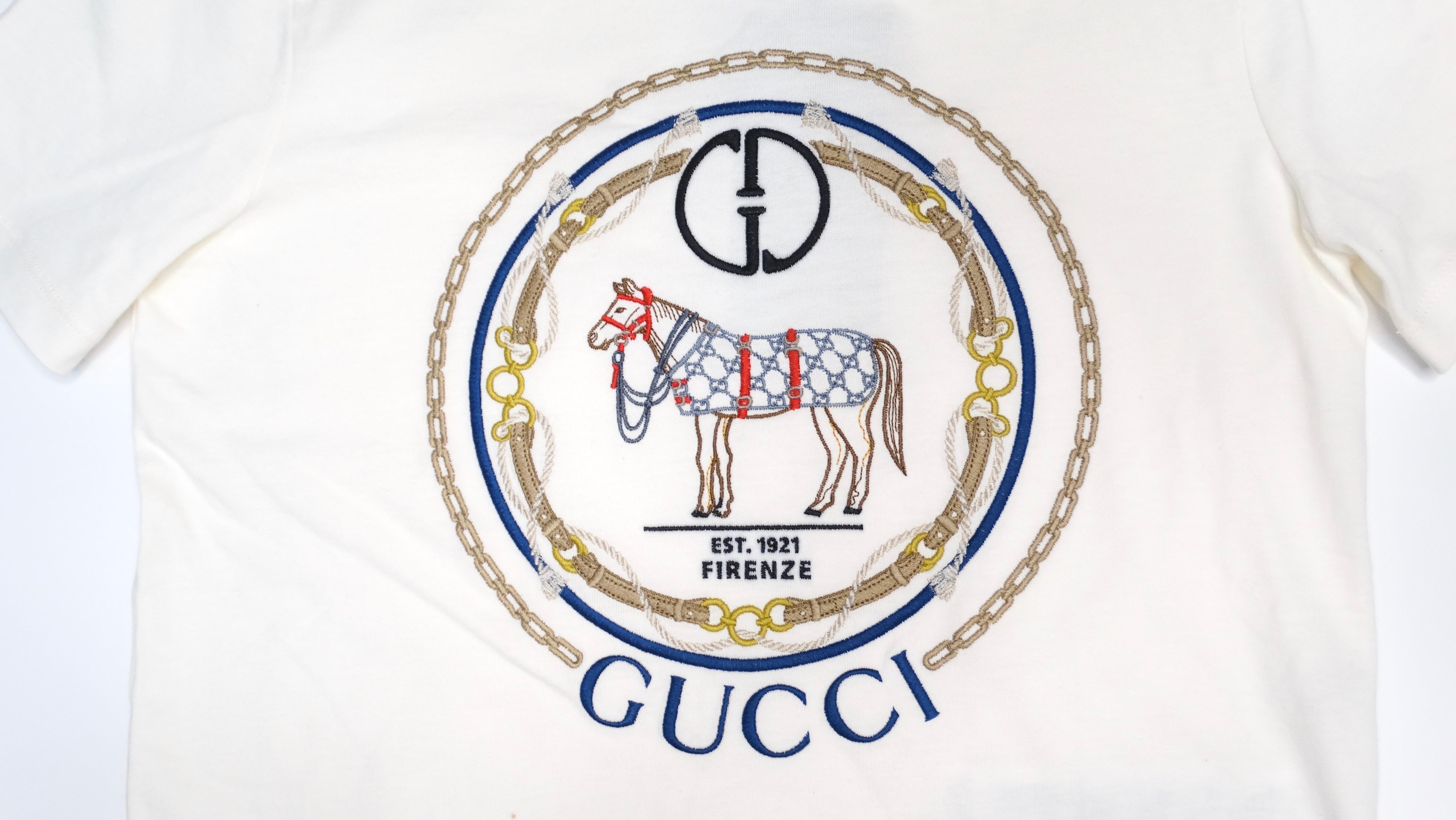 The Gucci Interlocking G Horse Motif Cotton T-Shirt is a sophisticated blend of classic and contemporary style. Crafted in Italy from 100% premium cotton, this white T-shirt is adorned with an intricate horse motif that highlights Gucci’s iconic