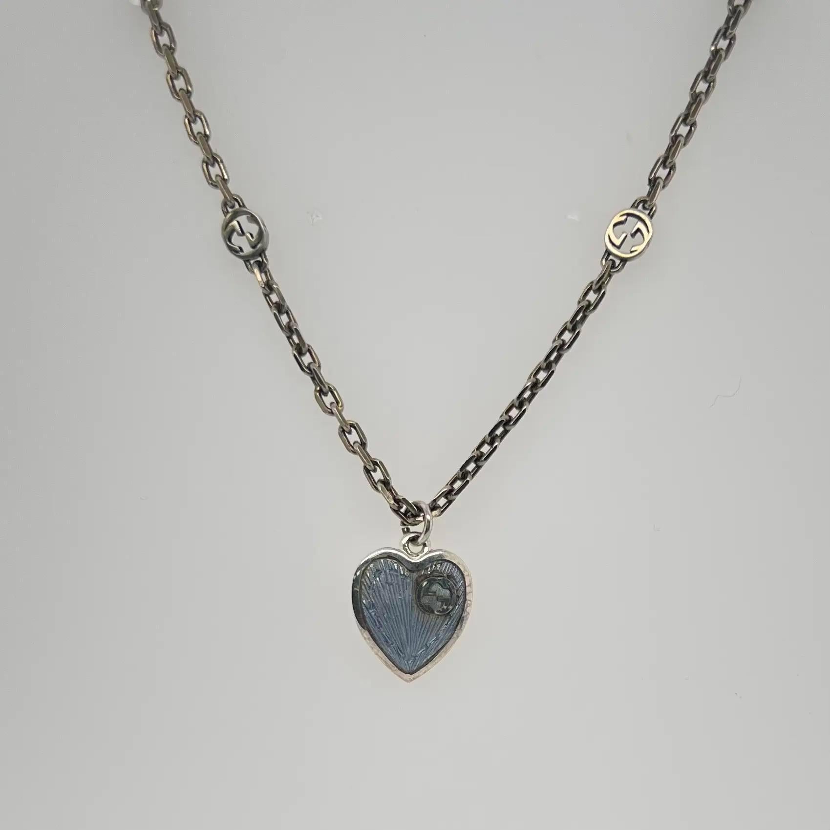 This Beautiful GUCCI necklace is imbued throughout with the emblematic Interlocking G motif with an engraved heart pendant animated by light blue enamel. Designed in 925 sterling silver with semi shiny finished chain. Secured with a lobster lock.
