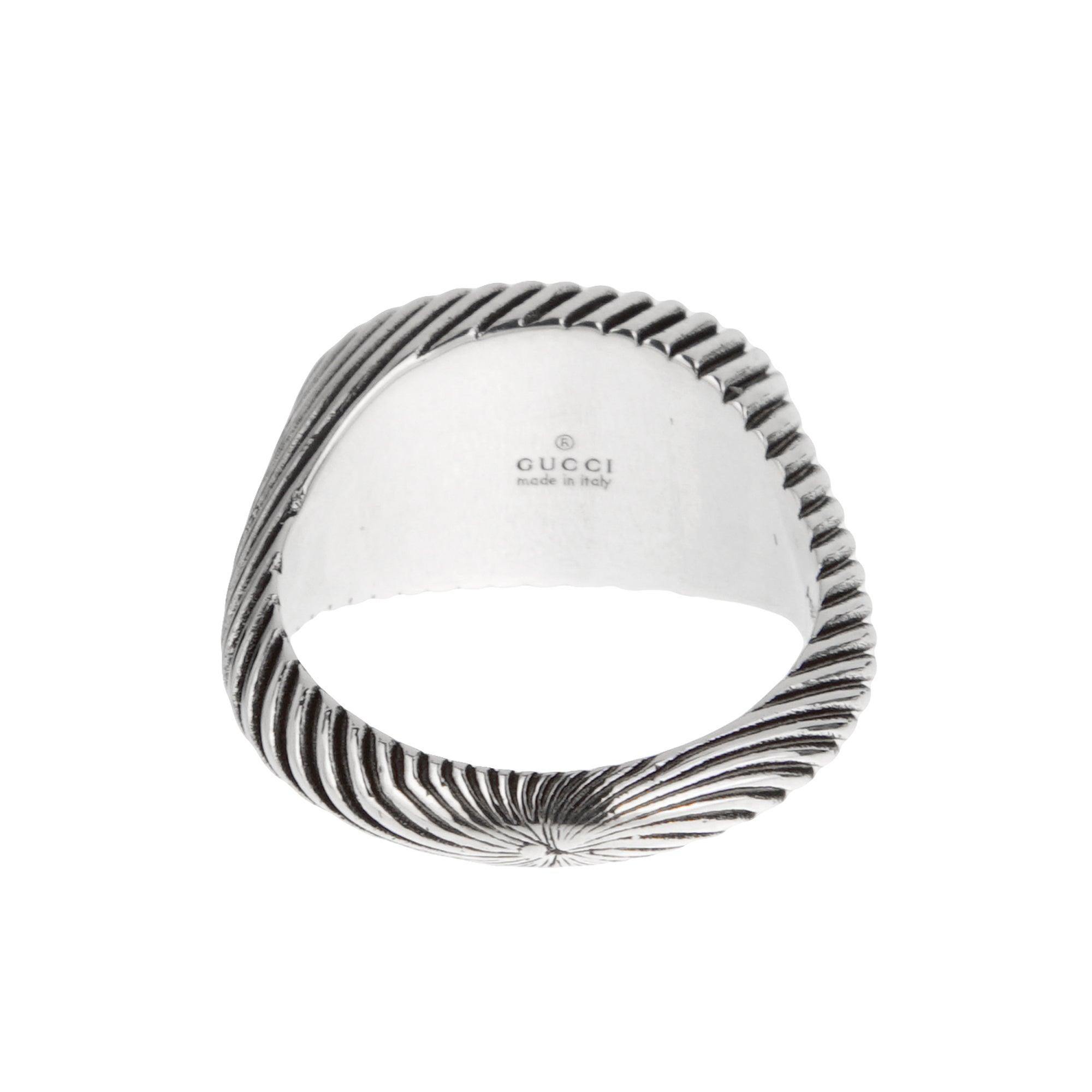 Anello Gucci con motivo a corda con G intrecciata, realizzato in argento sterling. Presenta l'iconico logo G intrecciato, incorniciato da un motivo a corda intricato, che aggiunge profondità e una texture di ispirazione vintage. La classica