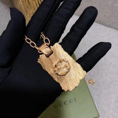 Gucci Collar con Colgante de Placa de Rayas de Metal con Textura G Entrelazada en Tono Dorado