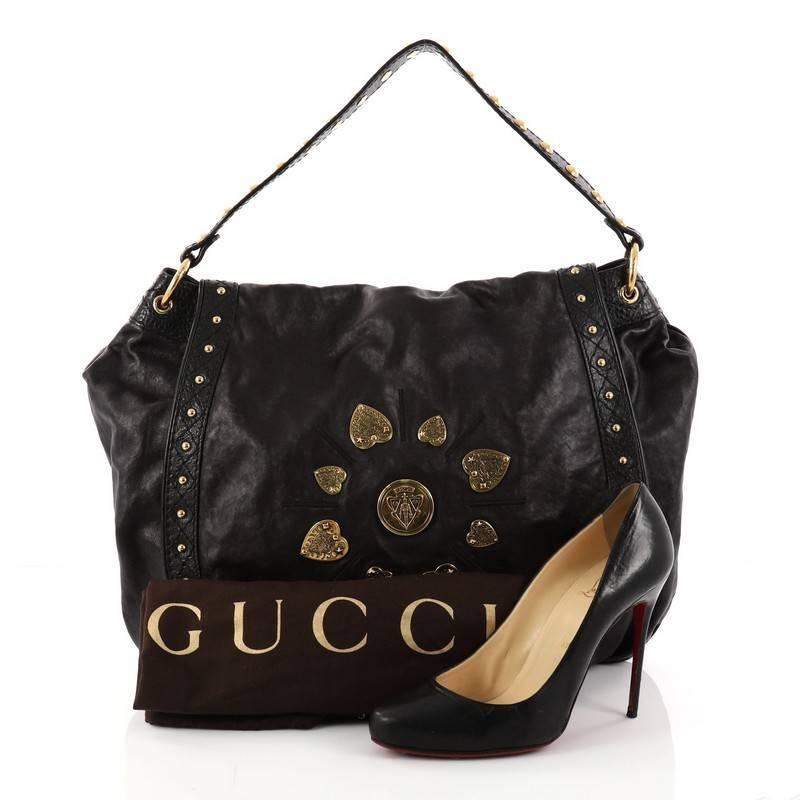 This authentic Gucci Irina Babouska Shoulder Bag Leather is a lovely addition for any Gucci lover. Crafted from supple black leather, this shoulder bag features Gucci medallion embellishments at its front center with engraved crested hearts, studded