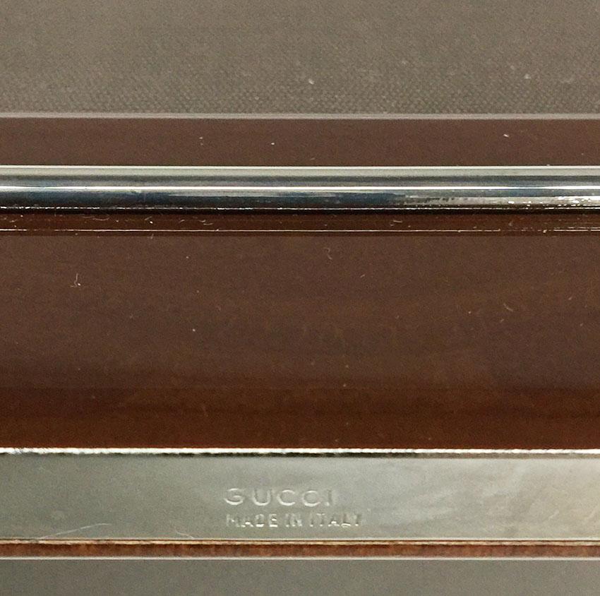 Brown Lacquered Picture Frame with Silver Plated Horsebit by Gucci, 1970s

Italian Gucci picture frame, brown lacquered with silver plated frame and two horse bit lines processed on the lacquer
Marked with logo Gucci on the button backside
Marked at