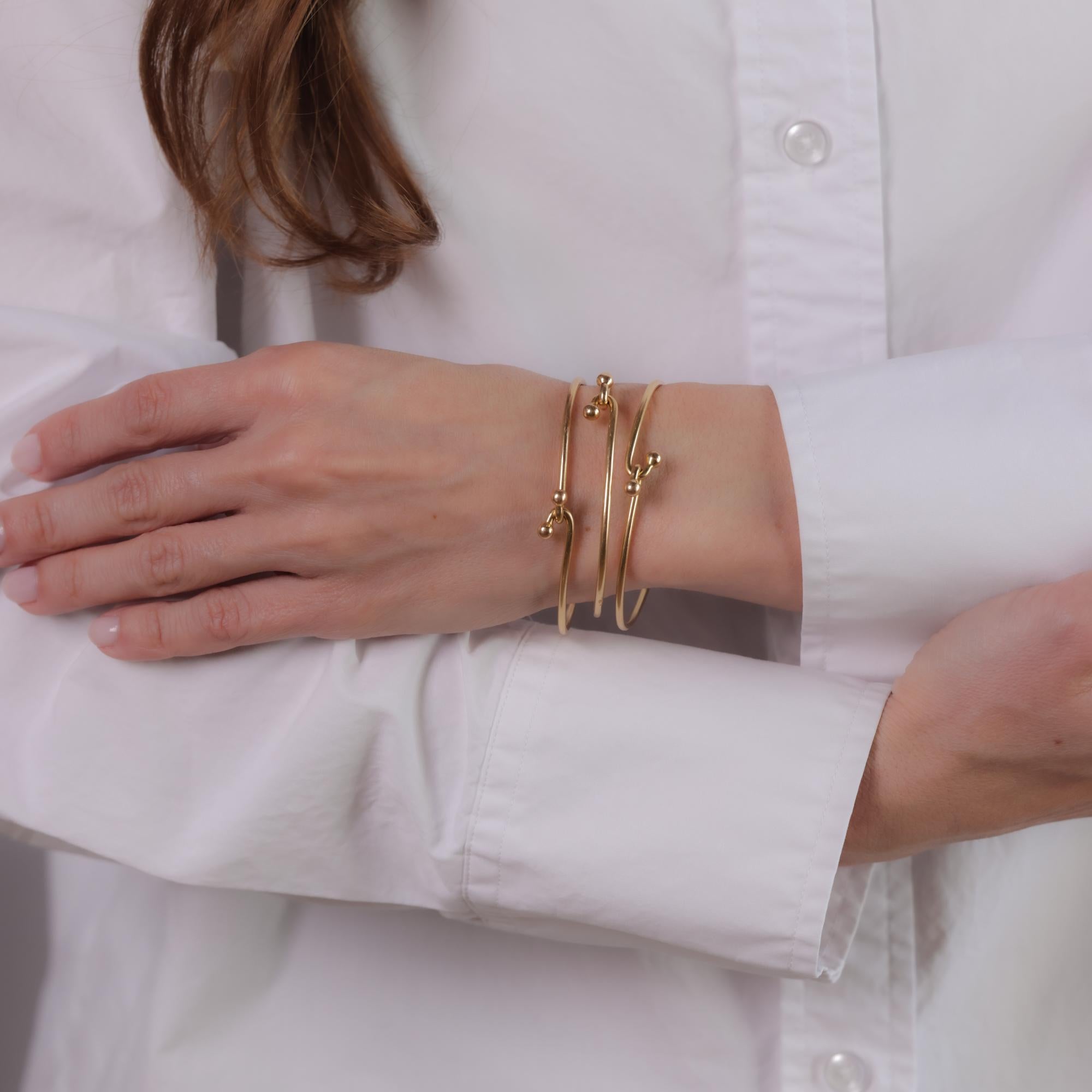 This vintage Gucci bangle is crafted in 14k yellow gold and hallmarked with a signature, 
