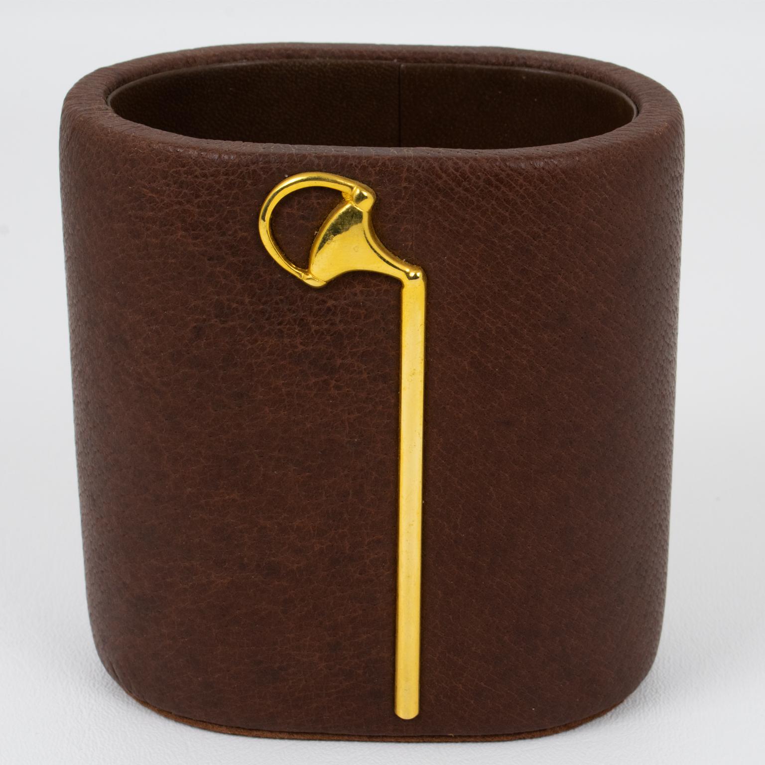 Gucci Italy designed this luxury modernist desktop accessory during the 1970s. The pen cup holder is made of cocoa brown fine calf leather and is ornated on both sides with a 24K gold plated equestrian decor. This gorgeous addition to your next