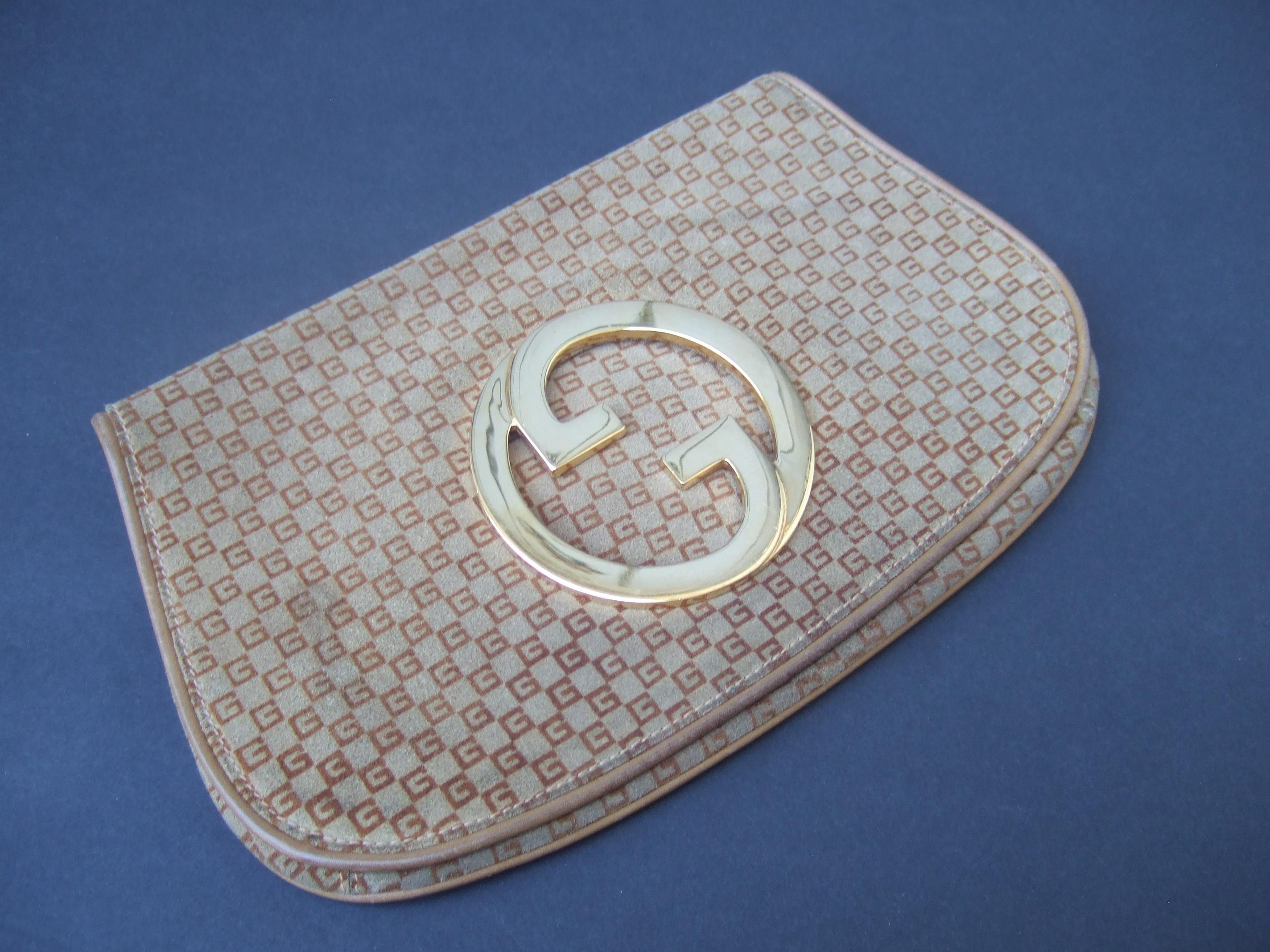 A.I.C. C.C., pochette en daim marron, c. années 1970
Cette élégante pochette des années 1970 est recouverte de daim marron clair. 
Accentué par les subtiles initiales G.G. de Gucci, répétées sur l'ensemble de la pièce. 

Orné d'initiales G.G.