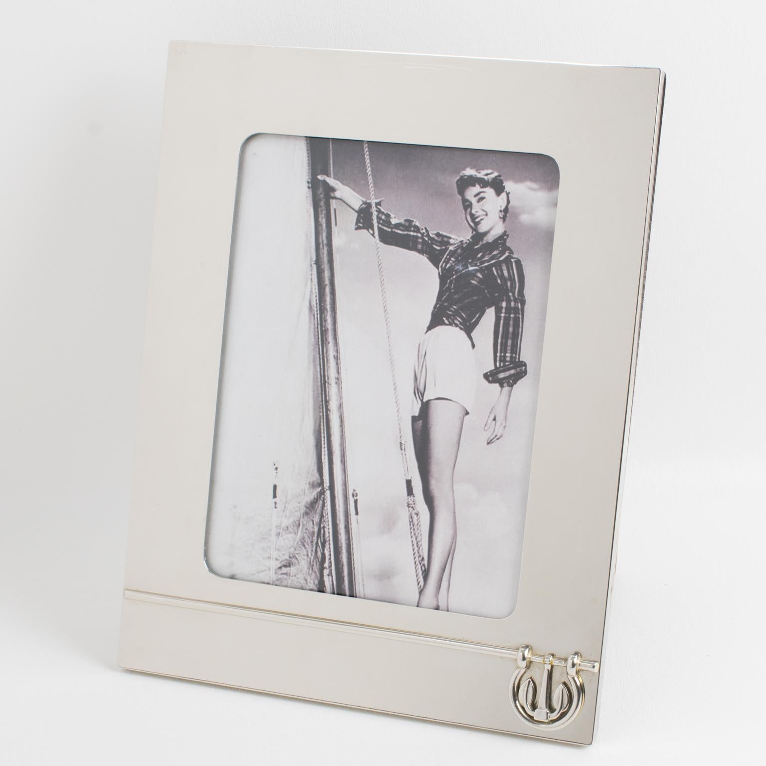 A sophisticated picture photo frame crafted by Italian designer Gucci. The piece boasts a chromed metal framing with a nautical design featuring an anchor and boat fittings. The back and easel are made of high-gloss walnut wood. The frame is marked