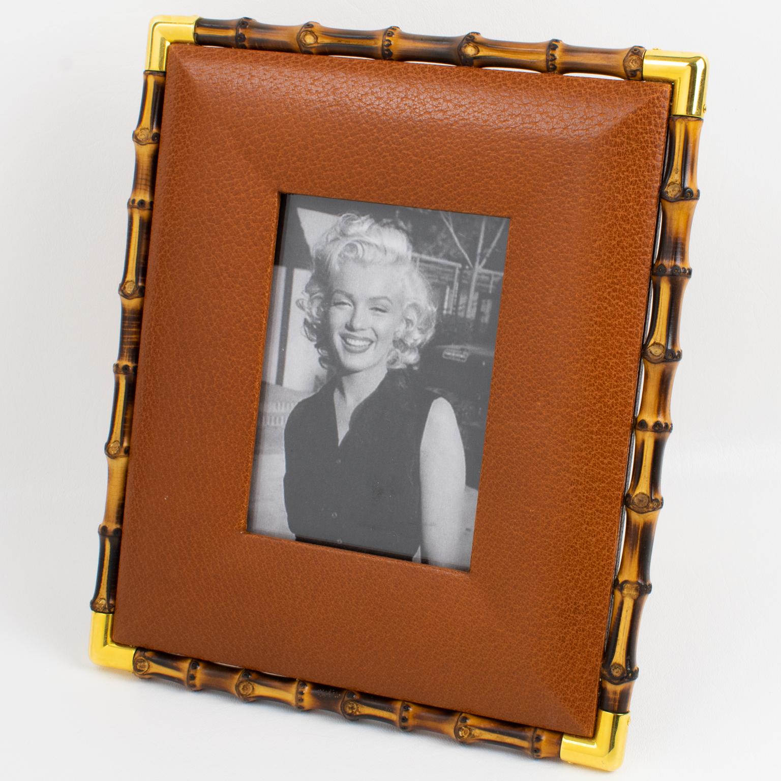 Italian designer Gucci manufactured this superb picture photo frame in the 1980s. The timeless and elegant golden brown cognac calfskin leather with a textured pattern is adorned with genuine bamboo and polished brass accents. The back and easel are