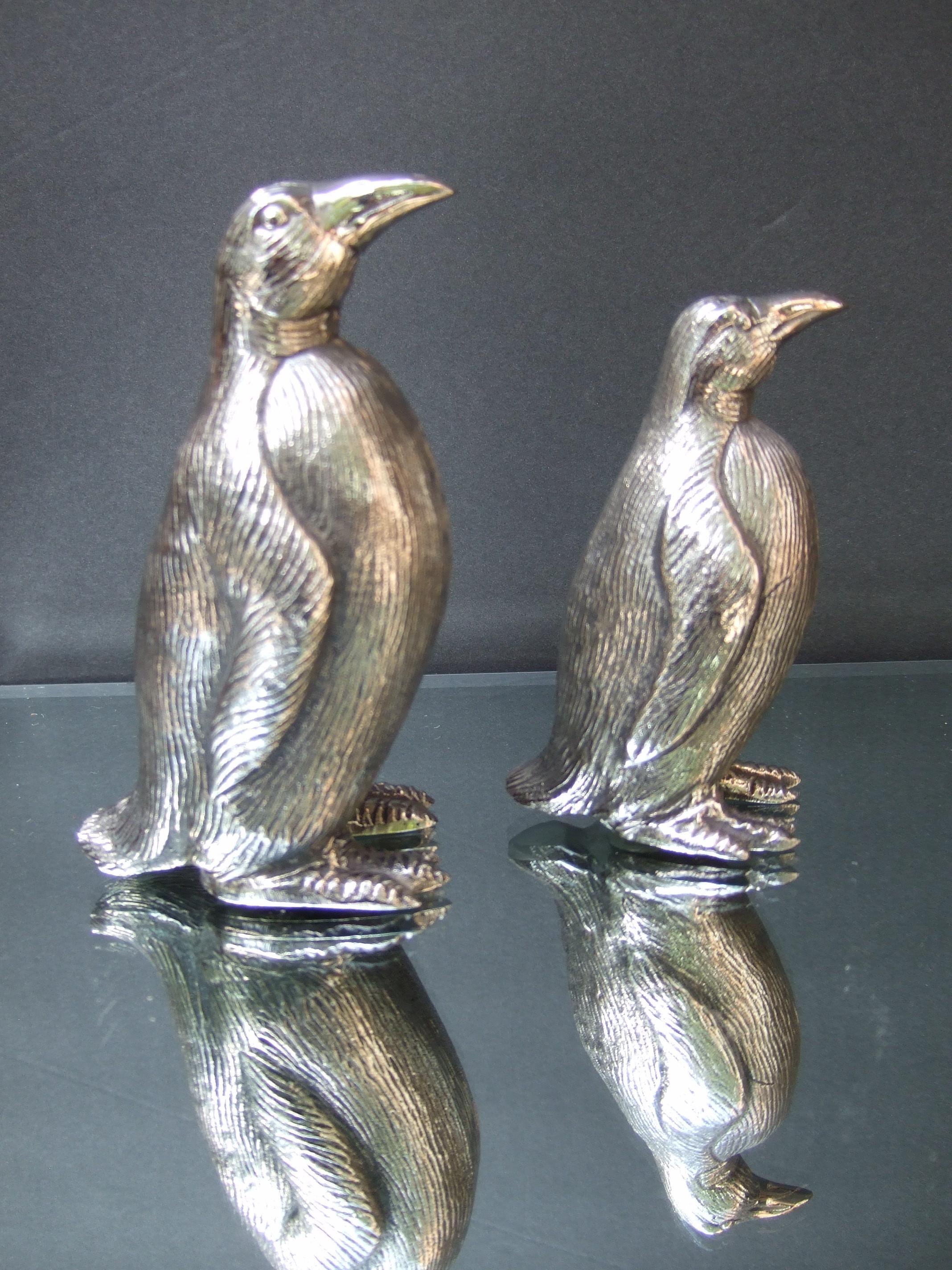 Gucci Italy Elegant pair of silver metal penguin salt & pepper shakers c 1970s
The endearing pair of stylized penguin figures are designed in graduated heights 
Embellished with etched detail that emulates their feathers 
The pair of penguin salt &