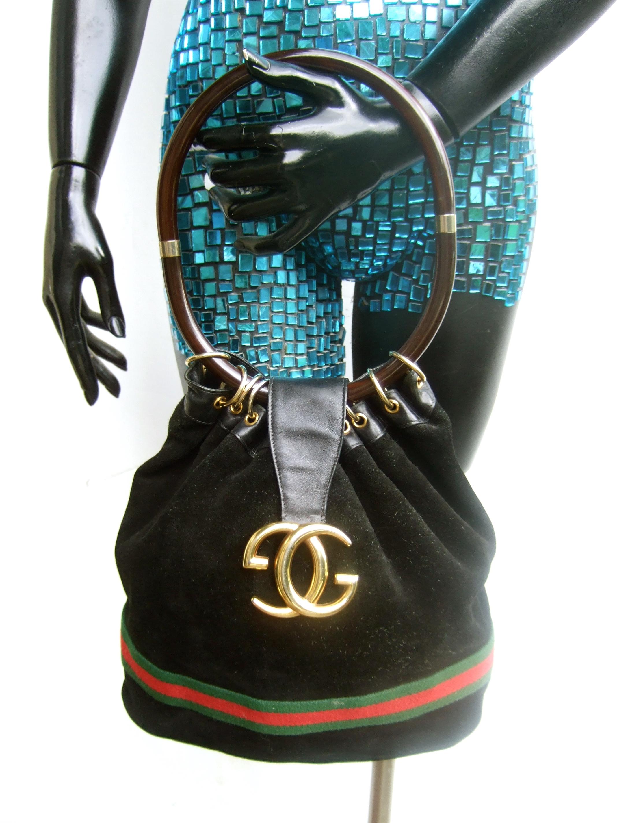 GUCCI Italy Extremely rare black suede amber resin lucite handle handbag c 1970s
The iconic Gucci handbag is covered with plush black doeskin suede
The flap cover anchoring the gilt metal G.G. logo initials in contrast 
is smooth black leather