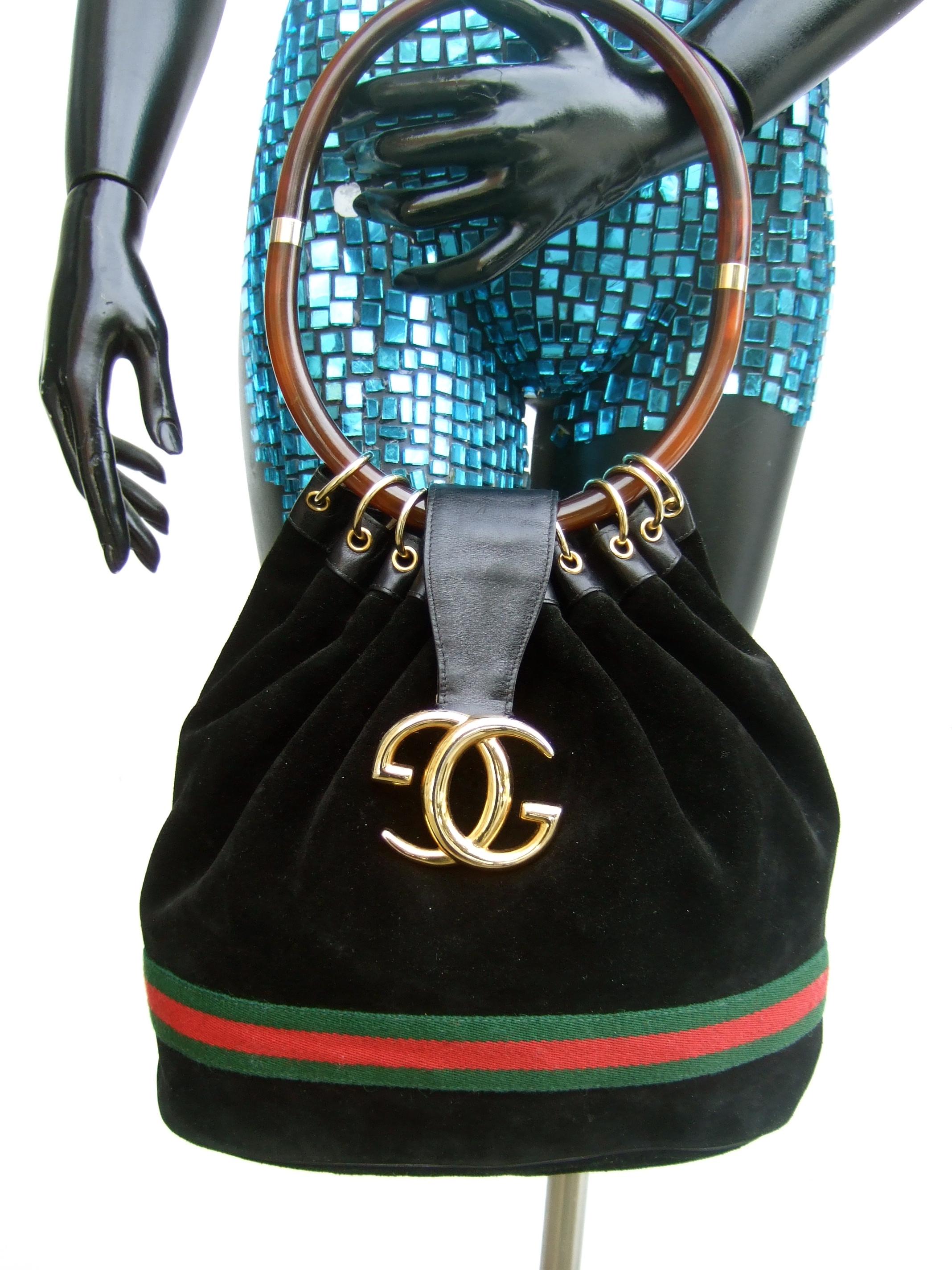 GUCCI Italy Extremely rare black suede lucite handle handbag c 1970s
The stylish Italian handbag is covered with plush black soft doeskin suede 
Carried with a large scale amber color oval shaped lucite handle 
Adorned with Gucci's iconic large gilt