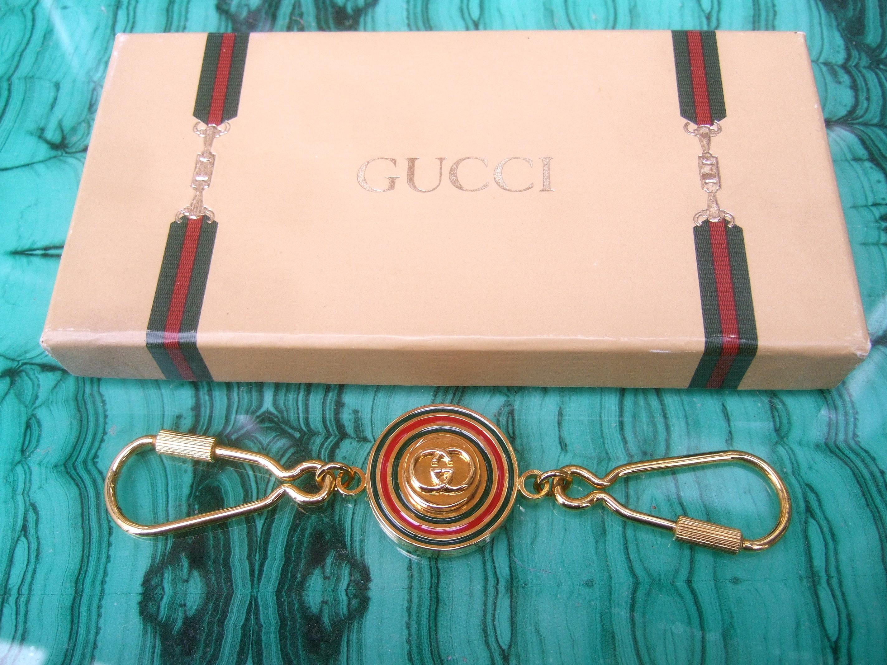 Gucci Italy Gilt enamel keychain in original Gucci cardboard presentation box c 1980s
The stylish unisex gilt metal keychain is designed with a circular medallion in the center
with Gucci's interlocked G.G. initials; framed with red & green enamel