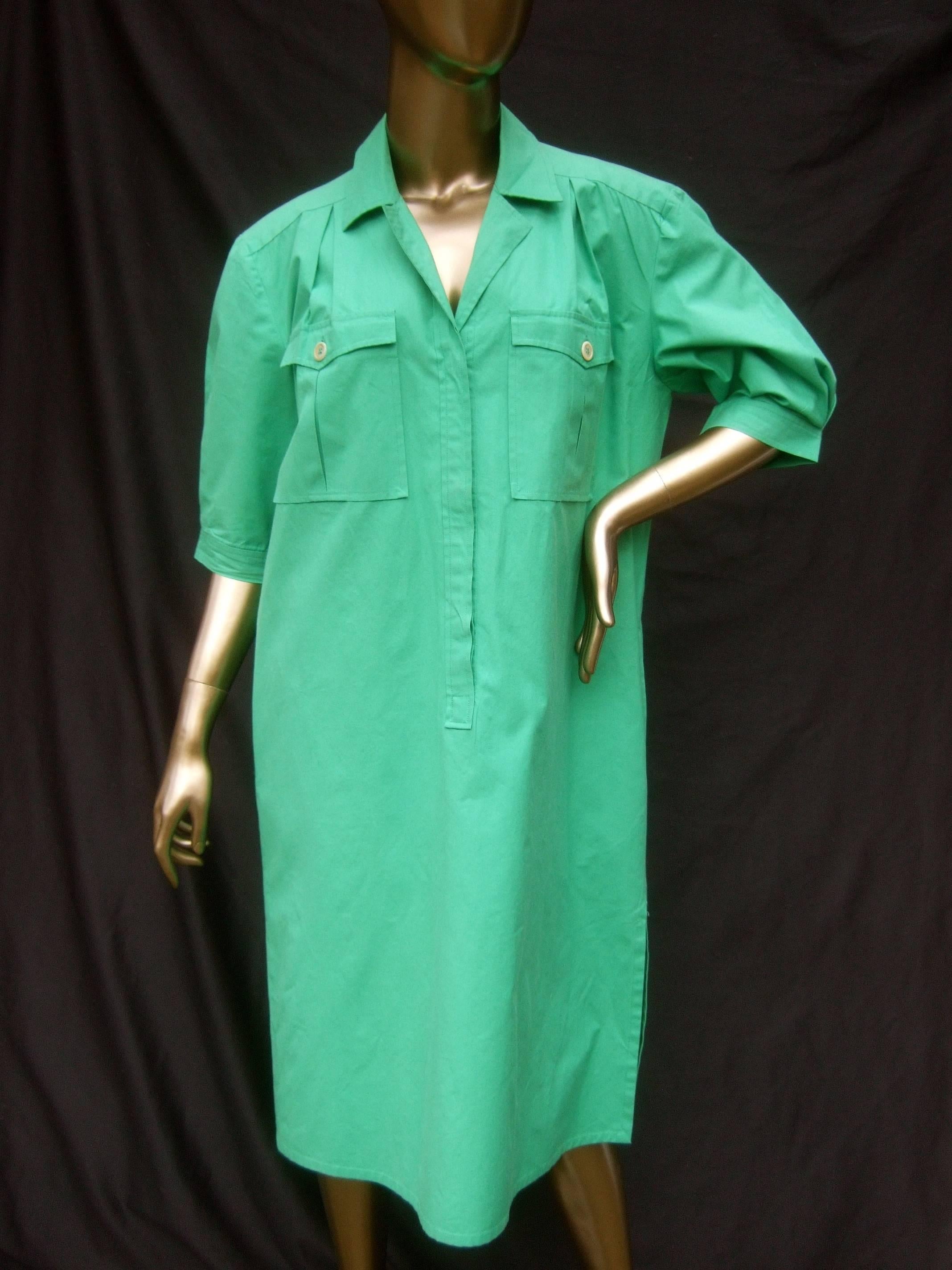Gucci Italy Green cotton crisp shirt dress c 1970s
The stylish Italian shirtdress is designed with cool
cotton fabric

The front bodice has a pair of flap cover buttoned
pockets. The buttons that run down the front are
concealed 

The shoulders,