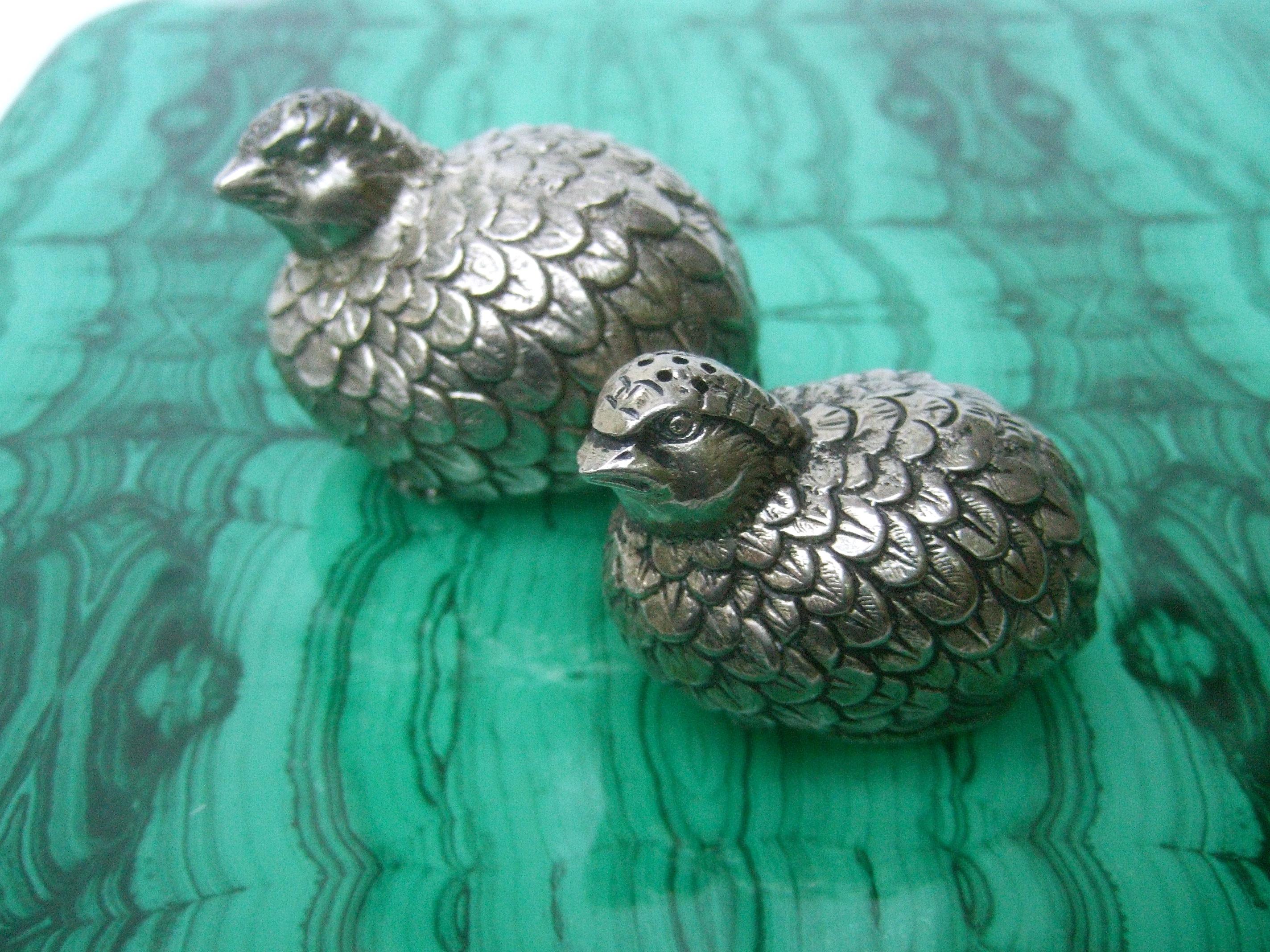 Gucci Italy Pair of silver metal quail salt & pepper shakers c 1970s
The elegant pair of salt & pepper shakers are designed in graduated sizes
Their plumage is distinguished with textured etched detail. The pair of bird theme salt & pepper shakers