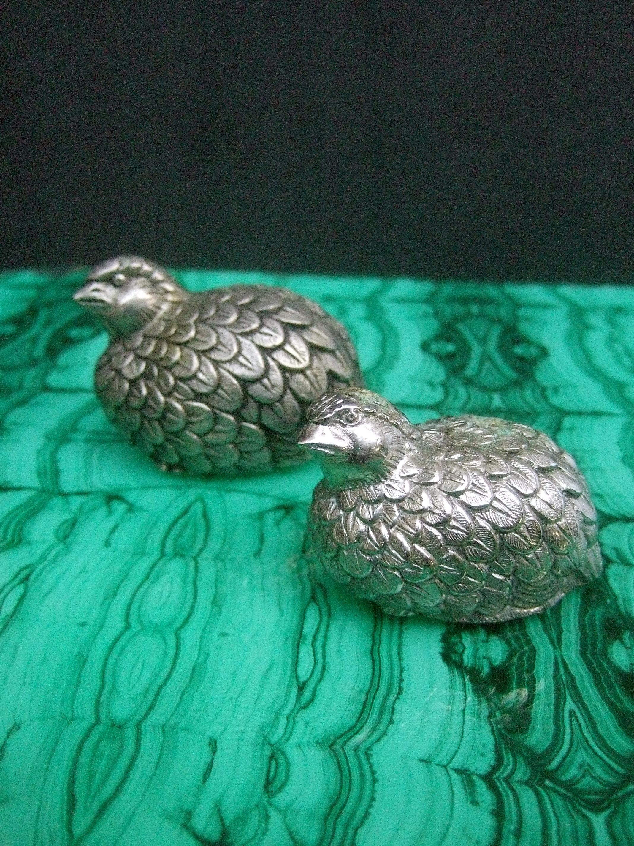 Gucci Italy pair of silver metal salt & pepper shakers c 1970s
Designed with a pair of graduated size quail birds
Both have etched impressed designs that emulate their plumage
Makes an elegant dining table decorative collectible 

The base of each