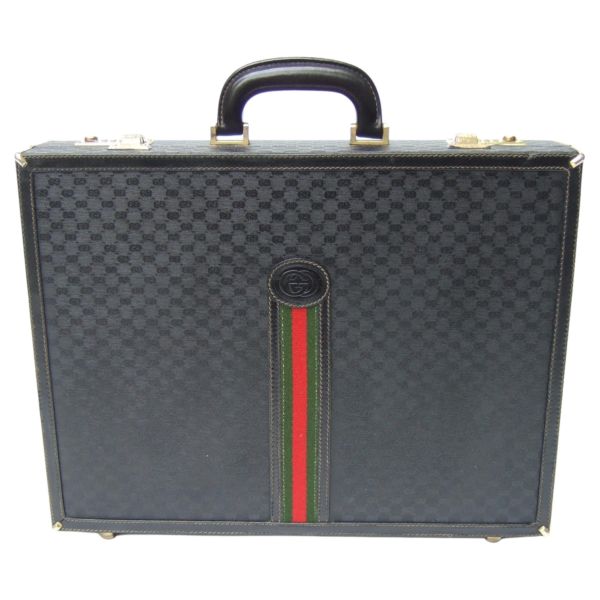 Gucci Italy Rare black coated canvas unisex briefcase c 1970s
The stylish Italian briefcase is designed with Gucci's signature
red & green canvas webbed stripe that runs down the front exterior

Covered with Gucci's coated canvas with their subtle