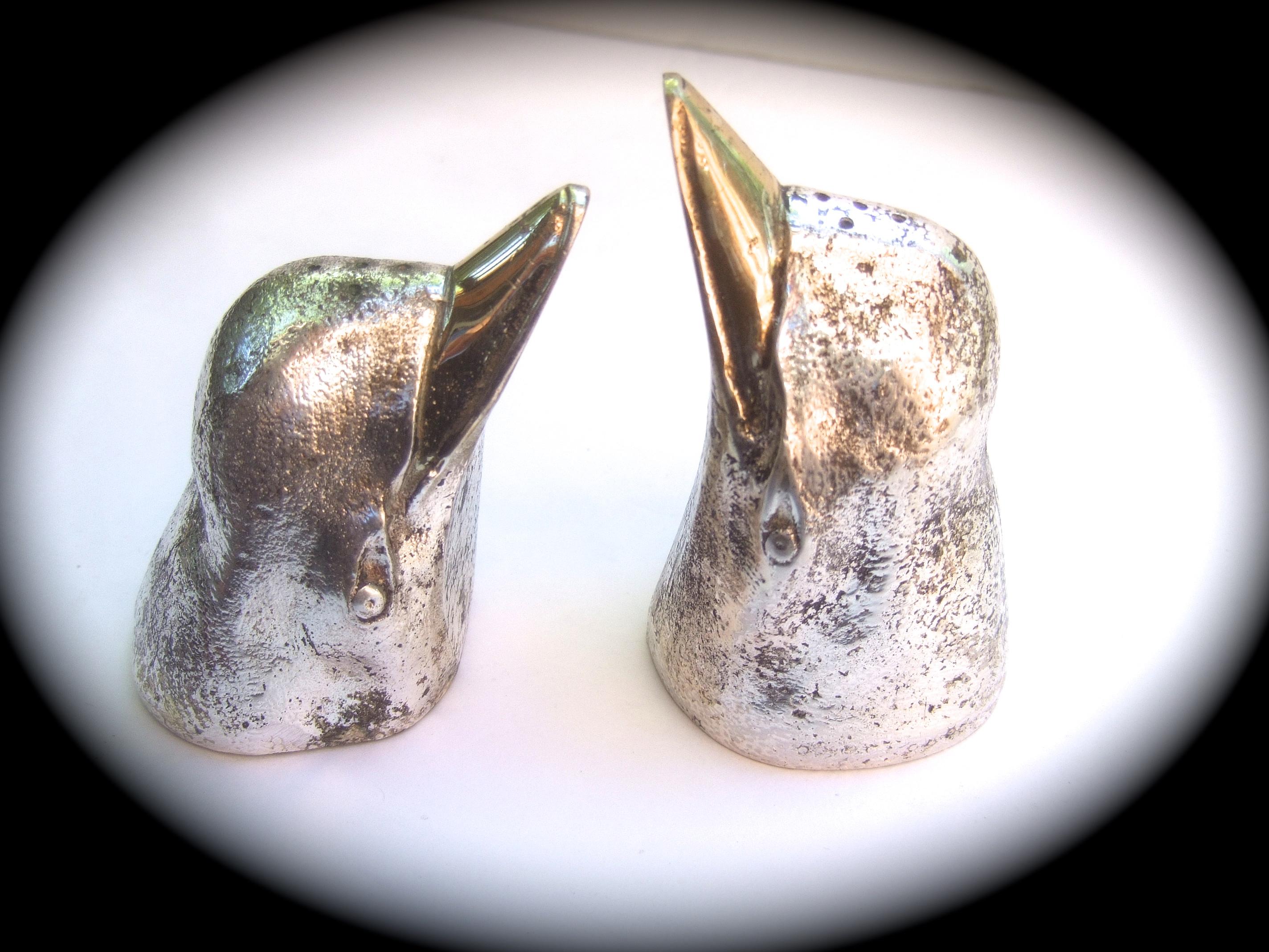 Gucci Italy Silver & gilt metal penguin salt & pepper shakers c 1970s

The unique pair of figural penguin spice shakers are designed with smooth gilt metal bills; in contrast their heads are sheathed in silver-tone satin metal that is textured with