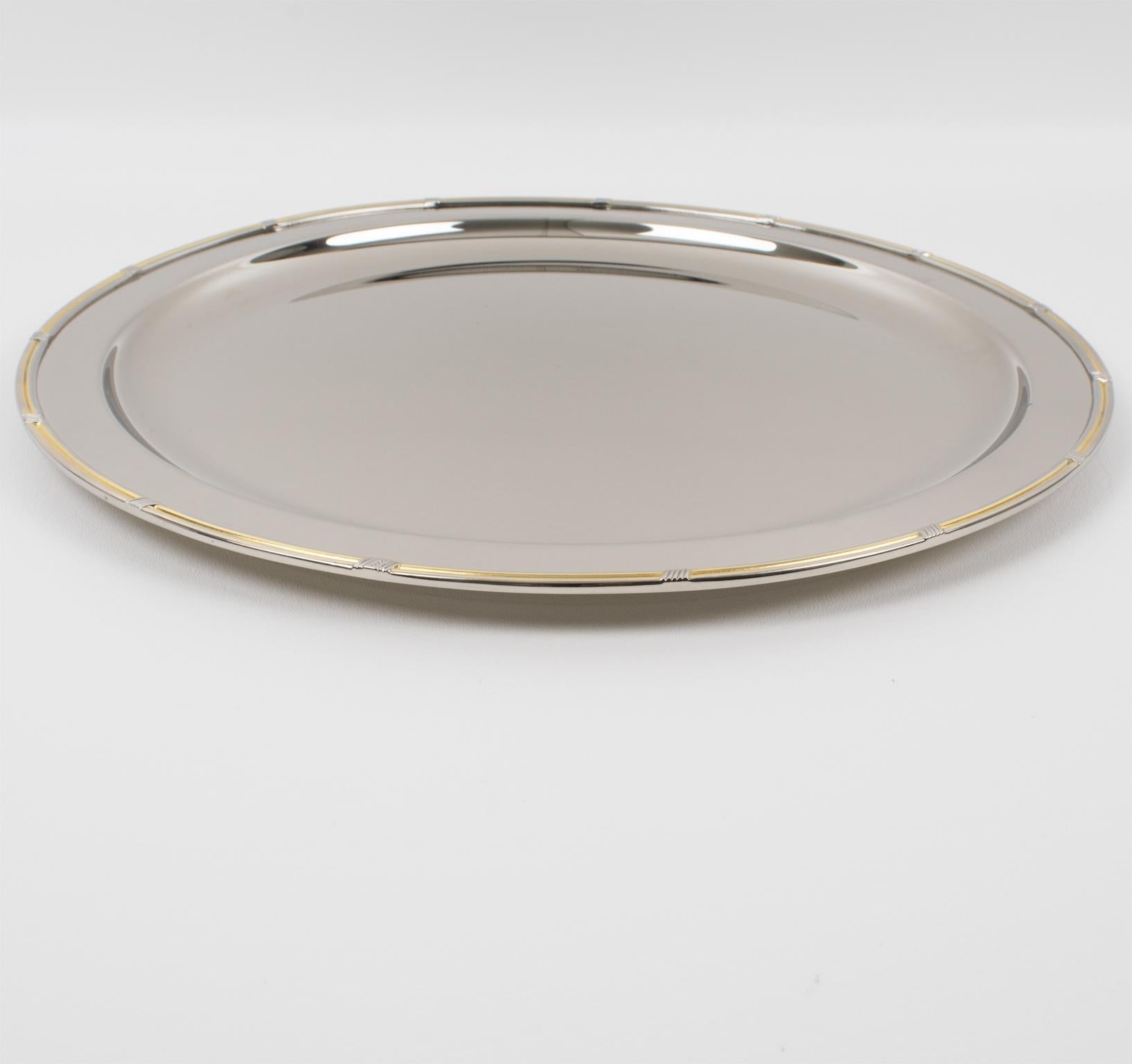 Gucci, Italy, crafted this luxury silver-plated metal barware serving tray in the 1980s. This bar accessory has a sleek and modernist design. It has a rounded shape with a raised edge and is made from a silver plate metal with an all-around carved