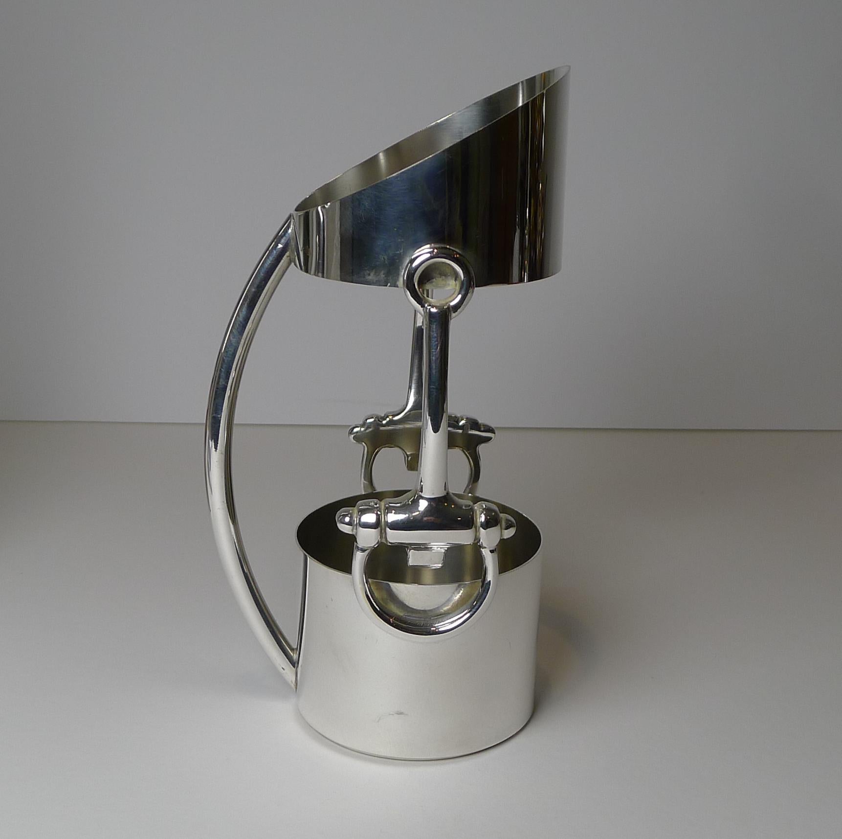 A very rare piece of vintage Gucci silver, dating to c.1970/1980. The Equestrian themed wine bottle holder / server is decorated with a horse bit mount each side and has an arched integral handle.

Just back from our silversmith's workshop where