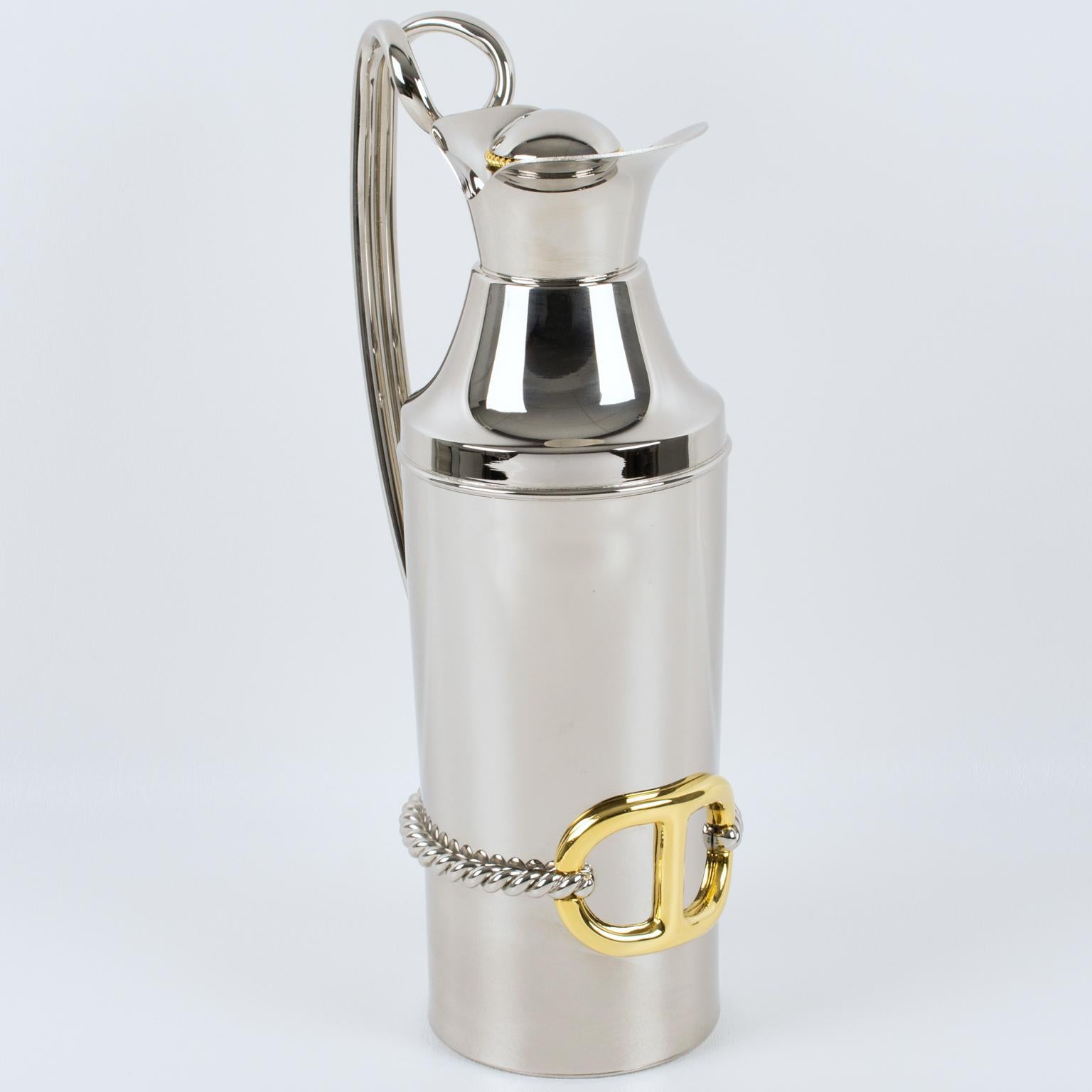 Gucci, Italy, crafted this luxury gold plated and silvered metal barware bar thermos, insulated decanter in the 1980s. This carafe features a sleek and modernist design made from silvered metal. 
The piece is adorned with a tall double-handle, 24K