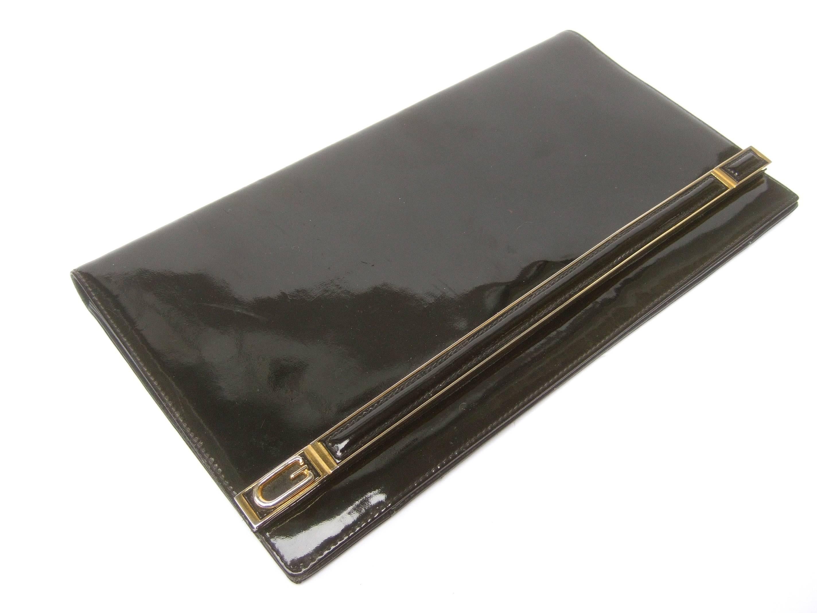 Gucci Sleek black patent leather clutch bag c 1970s
The stylish Italian glossy patent leather elongated
clutch bag is adorned with Gucci's G initial on one
of the corners

Running across the lower front flap cover is a matching
black patent leather