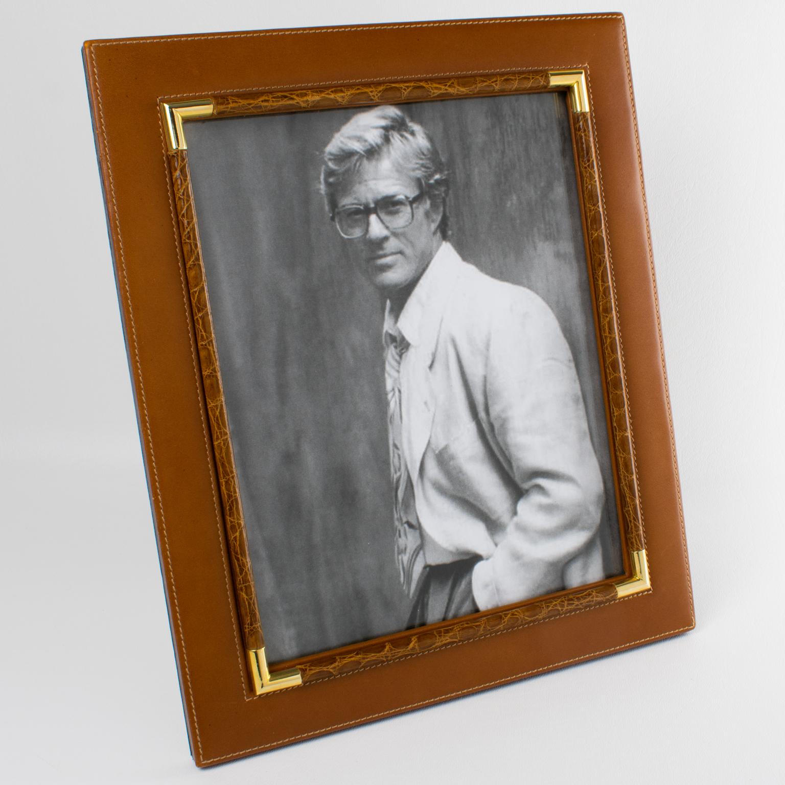 Italian designer Gucci created this luxury leather-and-brass picture frame. The piece was expertly crafted in Italy circa 1980. The timeless, stunning spice-brown calfskin leather is embellished with genuine crocodile-skin decor and polished, gilded