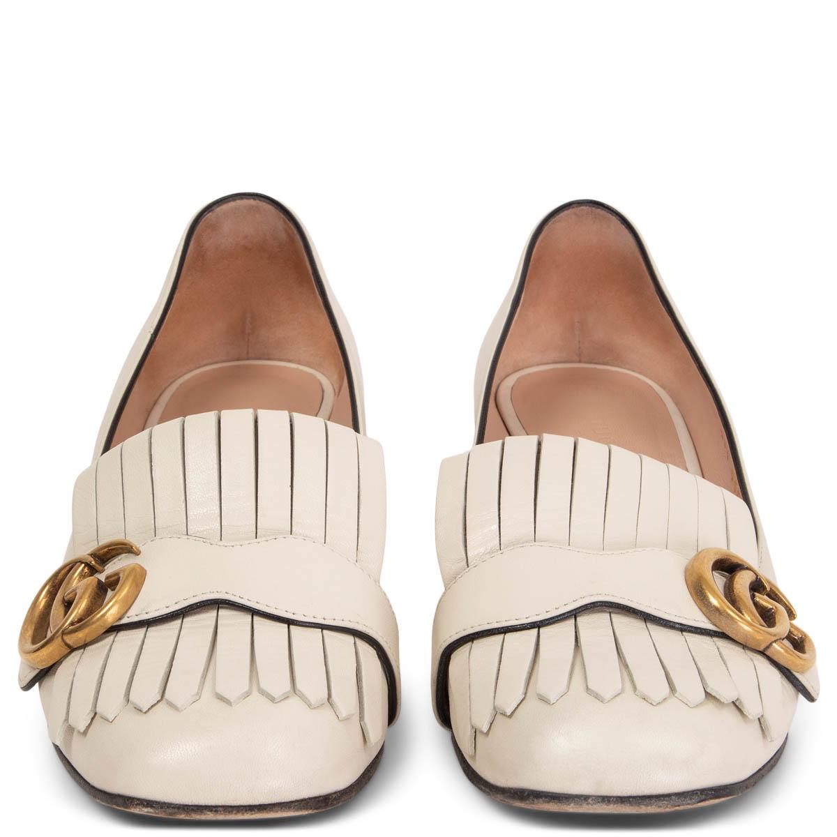 100% authentic Gucci Marmont mid-heel pump in ivory calfskin with Double G antique gold-tone hardware detail on fold over fringe. Have been worn with a scratch on the heel and a small dent. Show a scratch and some soft wear to the tip. Overall in