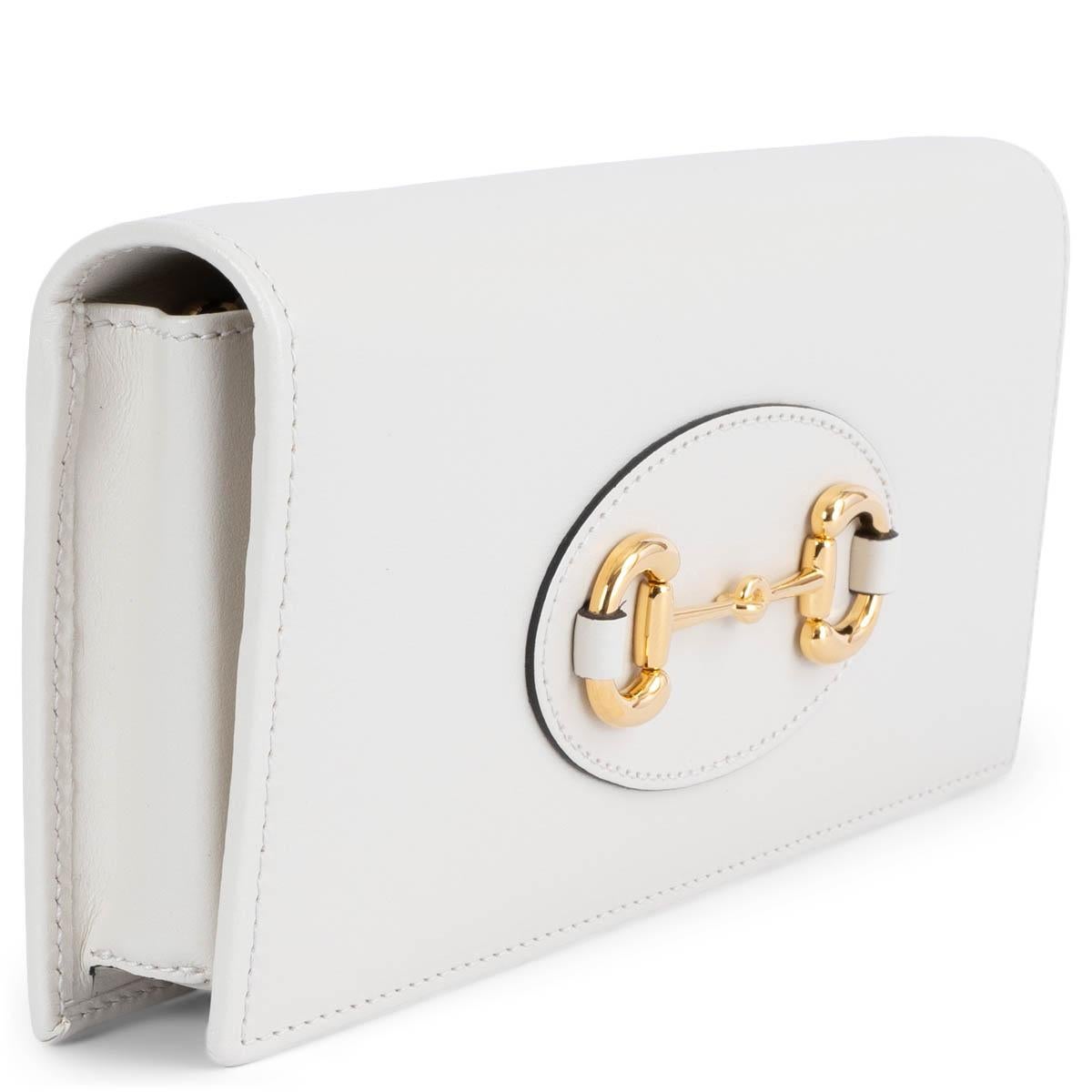 100% authentic Gucci Horsebit 1955 wallet in chain in ivory smooth calfskin featuring gold-tone hardware. Opens with a push-button and is lined in leather and nylon with one zipper pocket against the back. Chain-link shoulder-strap can get removed