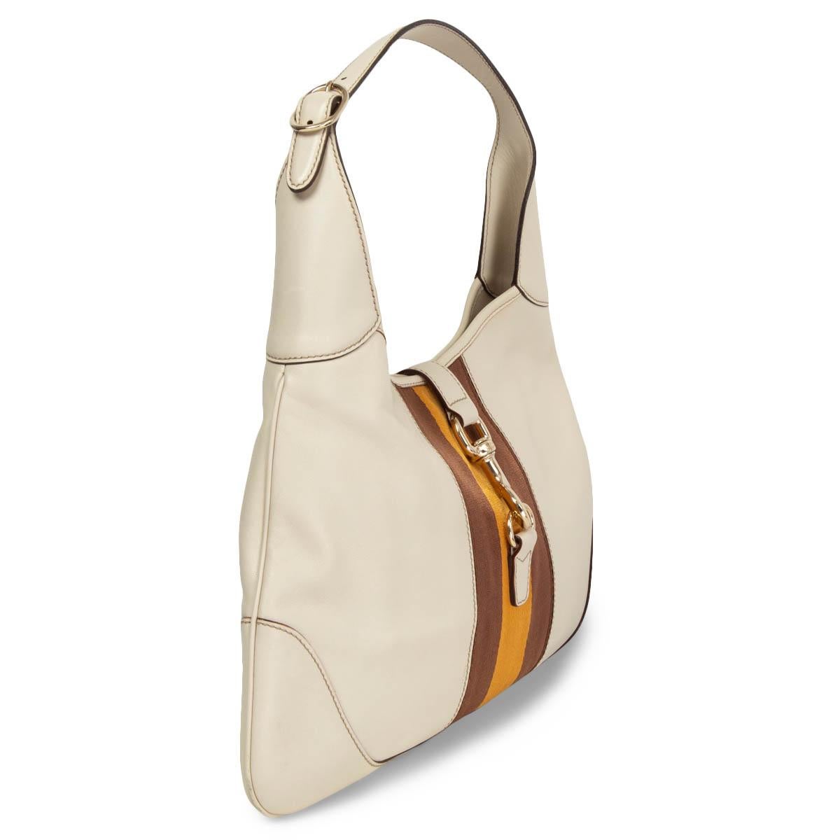 100% authentic Gucci Jackie O Bouvier Medium hobo in off-white leather with signature web stripe in brown and ochre canvas. The bag features a light gold-tone metal closure. Lined in oatmeal canvas with one zipper pocket against the back and a small