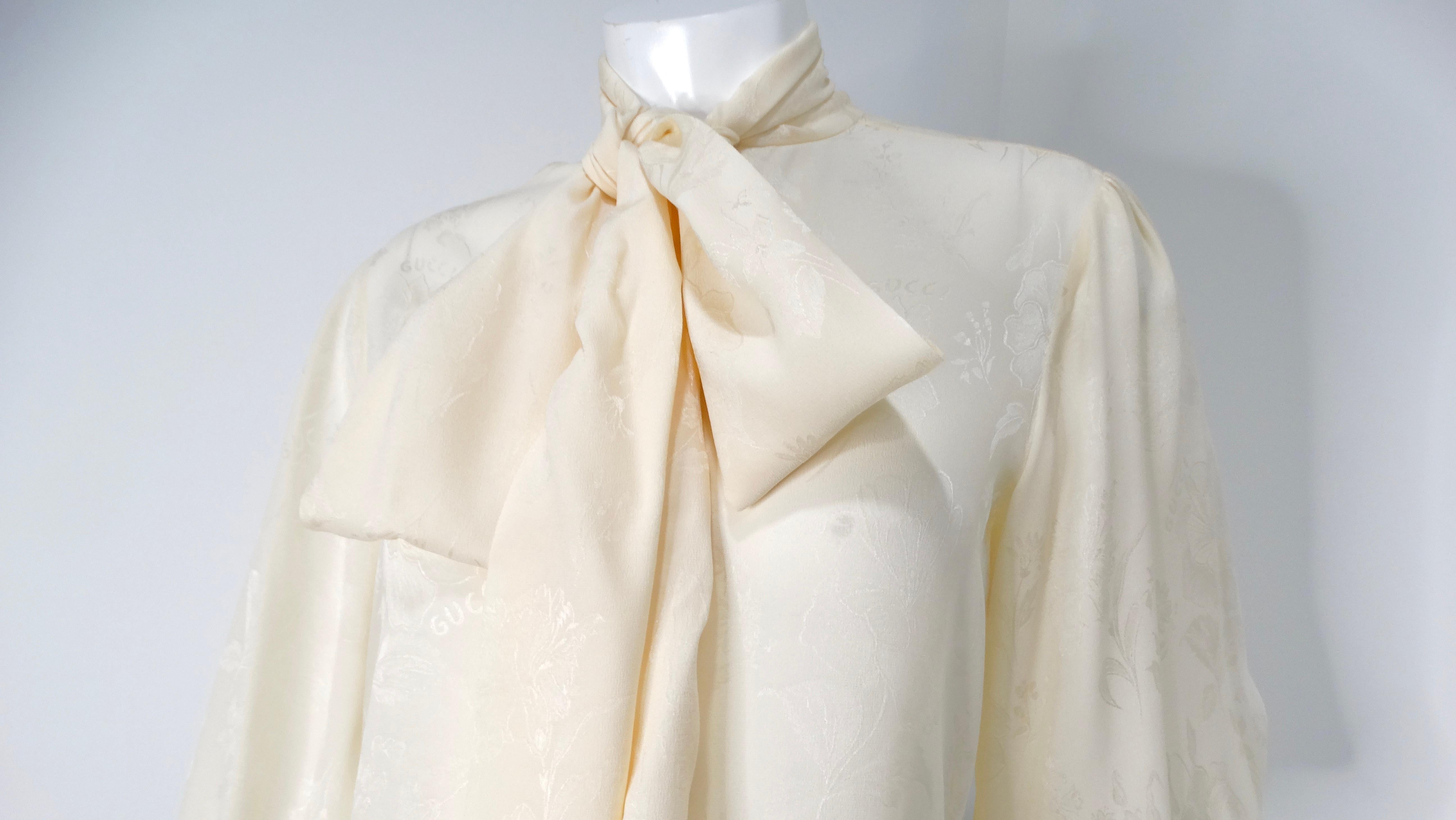The Gucci Ivory Romantic Floral Print Silk Bow Collar Button-Up Blouse is a stunning piece that effortlessly embodies the brand's luxurious aesthetic and attention to detail. Crafted from high-quality silk, this ivory blouse features a delicate