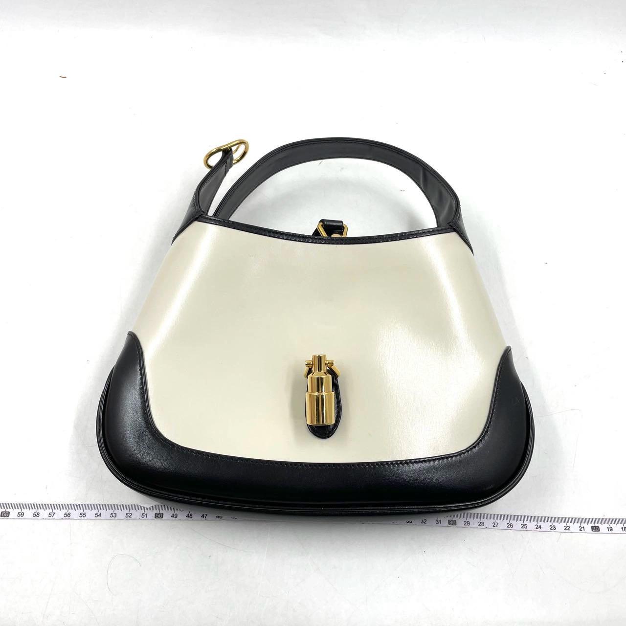 Die Gucci Jackie 1961 Black and White Small Bag ist eine moderne Interpretation eines kultigen Designs. Sie ist aus Leder gefertigt, hat eine strukturierte Silhouette und verfügt über einen Crossbody-Riemen, damit Sie Ihre Essentials überallhin