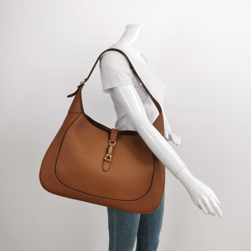 Gucci Jackie 1961 Caramel Tan Large Shoulder Bag with Strap
 These are professional photos of the actual bag offered by Luxbags.
 The Gucci Jackie 1961 Handbag is a modern take on an iconic design. Crafted in leather with a structured silhouette, it