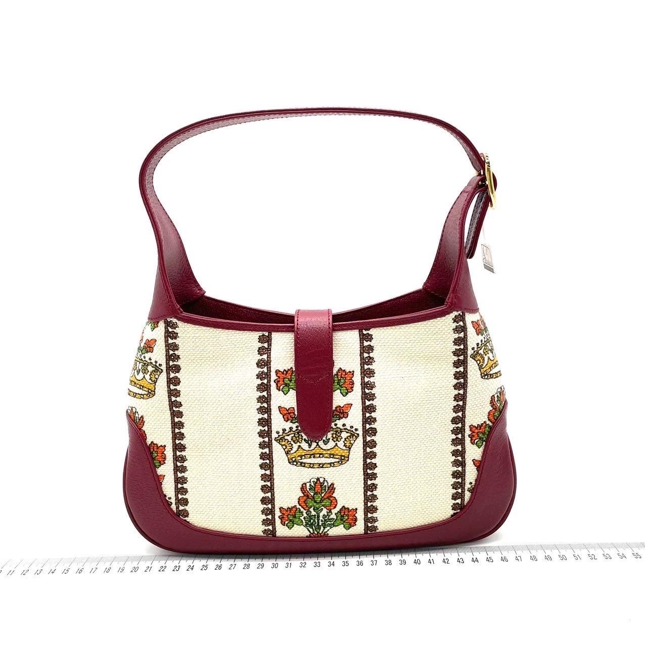 Questa Gucci Jackie 1961 è un'edizione speciale Gucci Centennial. È dotato di una maniglia superiore regolabile,  patta frontale con chiusura a pistone, stampa 