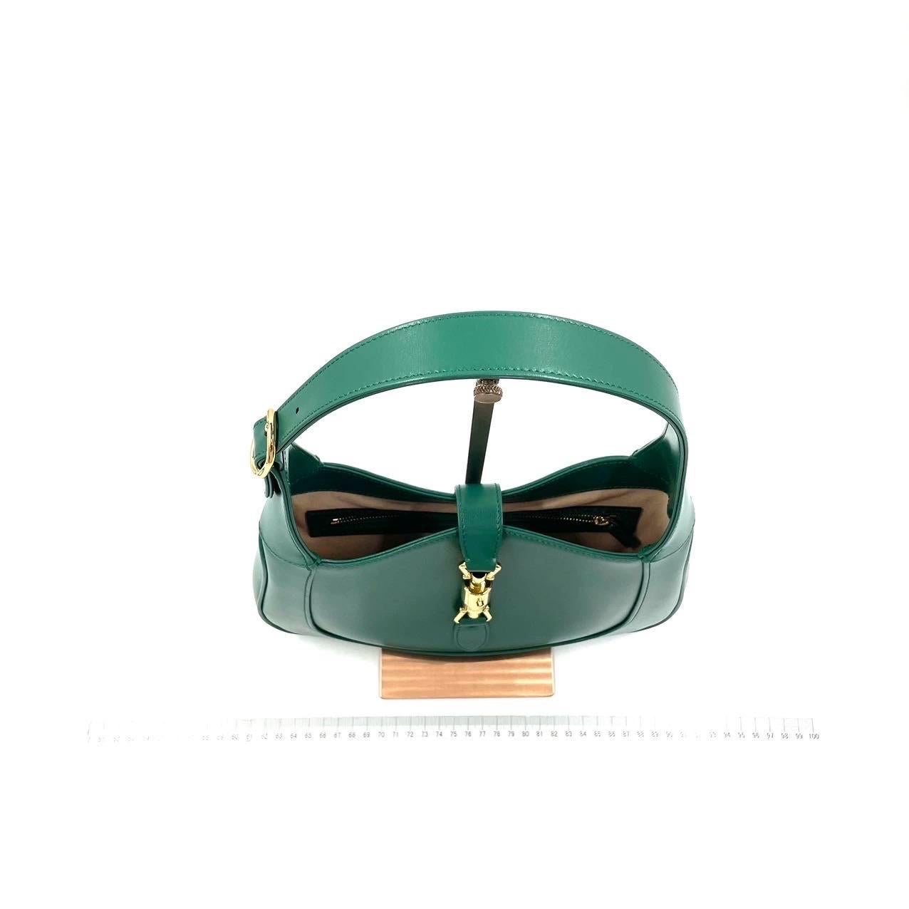 Die Gucci Jackie 1961 Green Small Tasche ist eine moderne Interpretation eines kultigen Designs. Sie ist aus Leder gefertigt, hat eine strukturierte Silhouette und verfügt über einen Crossbody-Riemen, damit Sie Ihre Essentials überallhin mitnehmen