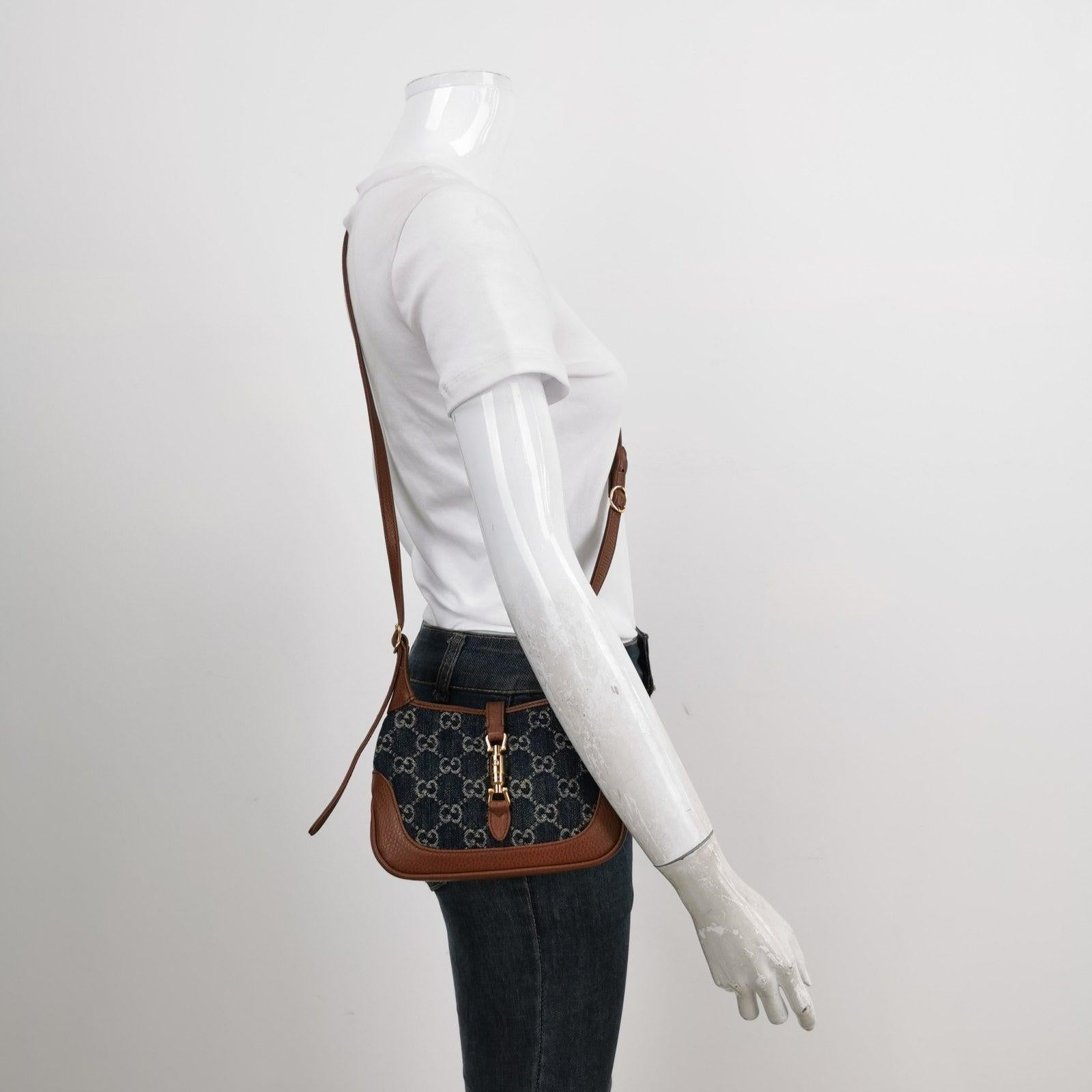Gucci Jackie 1961 Mini Handbag in Blue Monogram Denim and Brown Leather
  These are professional photos of the actual bag.
  The Gucci Jackie 1961 Mini Handbag is a contemporary interpretation of a timeless style. Crafted with premium leather and
