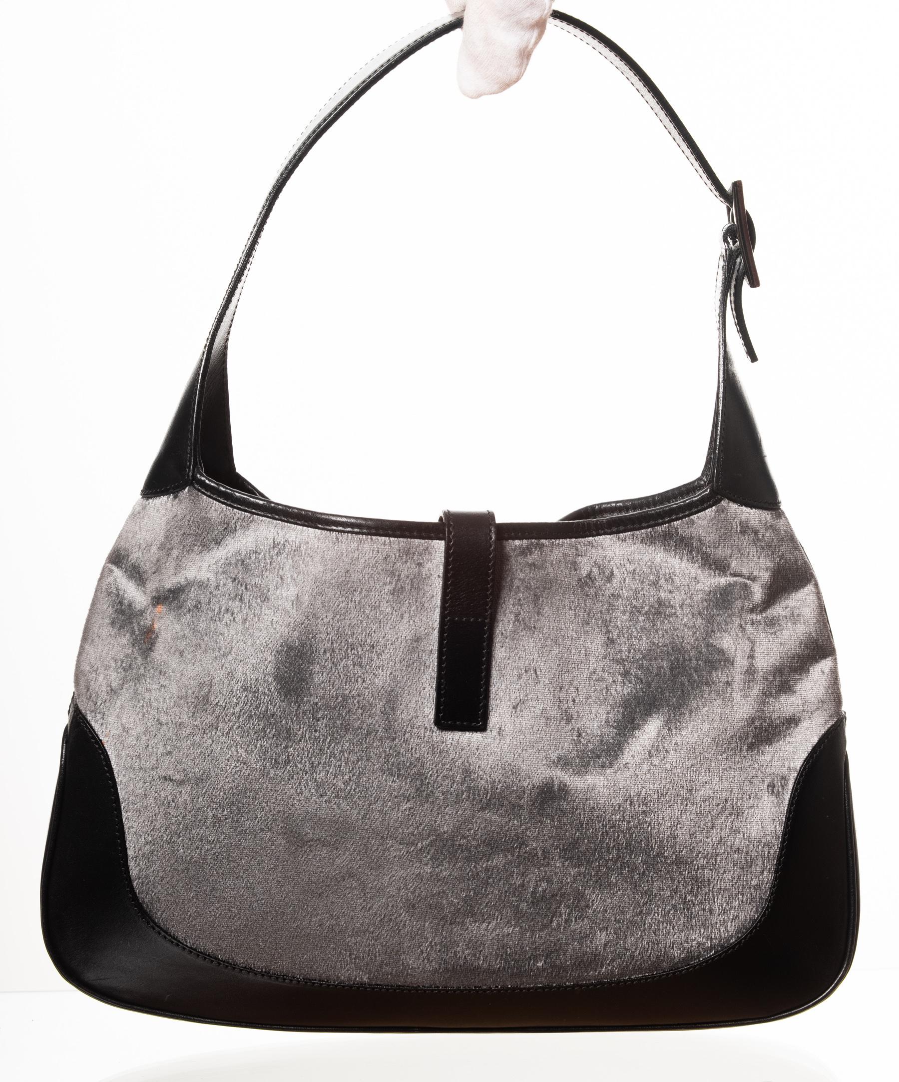 Gucci Jackie Hobo bag made of velvet and features leather finishes, push pin lock hardware closure and sateen fabric interior lining. One zip inside pocket with a leather pull tab. Leather Gucci logo on the inside pocket. Large silver color metal