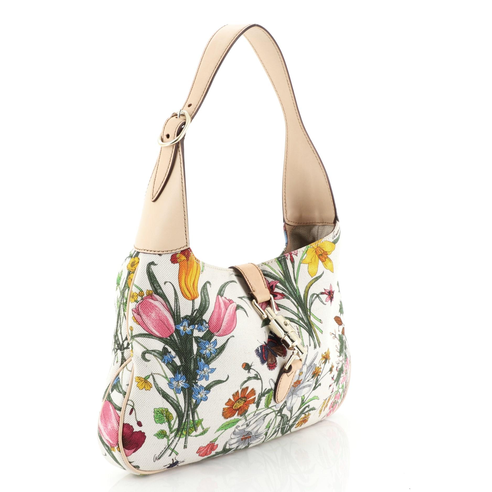 This Gucci Jackie O Bag Flora Canvas Small, crafted from multicolor flora canvas, features an adjustable shoulder strap and gold-tone hardware. Its piston lock closure opens to a beige fabric interior with side zip pocket.

Estimated Retail Price: