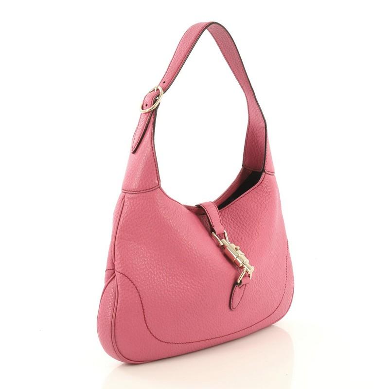 This Gucci Jackie O Bouvier Hobo Leather Medium, crafted from pink leather, features an adjustable shoulder strap and gold-tone hardware. Its piston-strap closure opens to a black leather interior with side zip pocket. 

Estimated Retail Price: