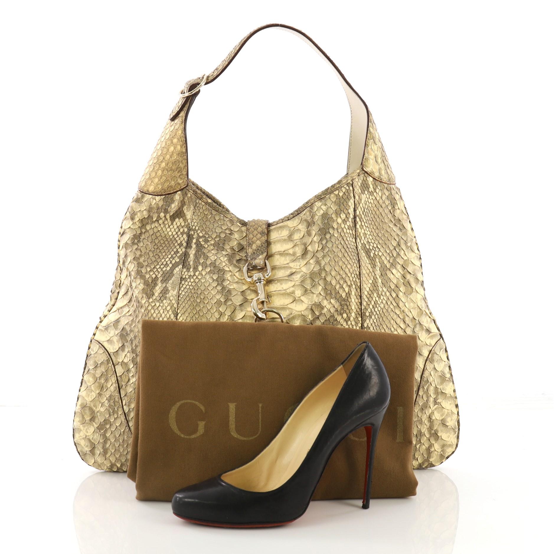 This Gucci Jackie O Handbag Python Large, crafted from genuine gold python skin, features an adjustable shoulder strap and gold-tone hardware. Its hook closure opens to a beige fabric interior with side zip and slip pockets. **Note: Shoe