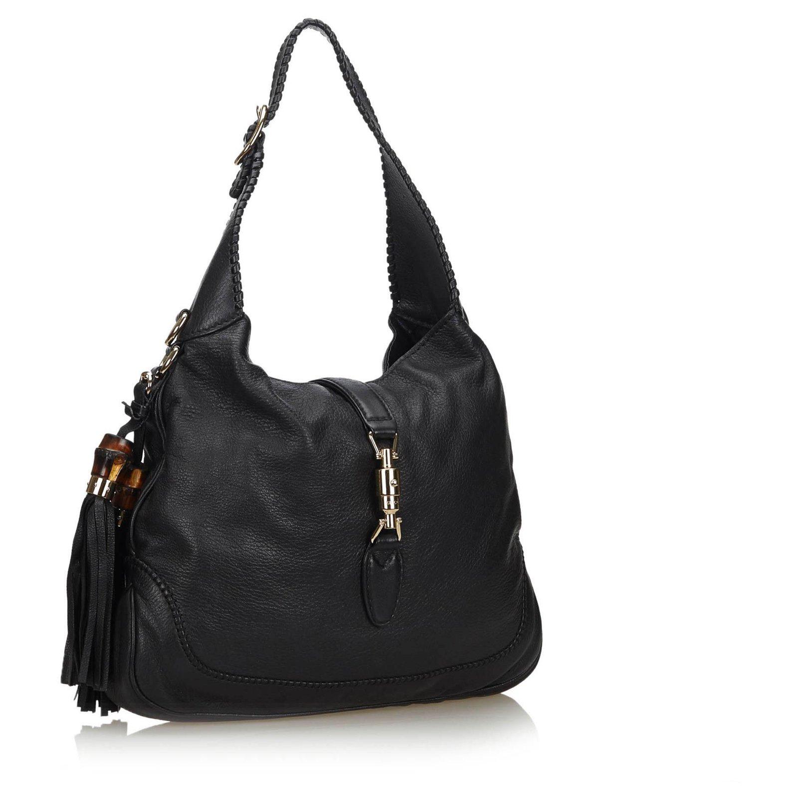 This hobo bag is made with pebbled calfskin leather with whipstitch trim. The handbag features an attachable shoulder strap, leather tassels with bamboo knobs and a cross over strap with a sliver tone metal piston lock. The top is open to Gucci logo